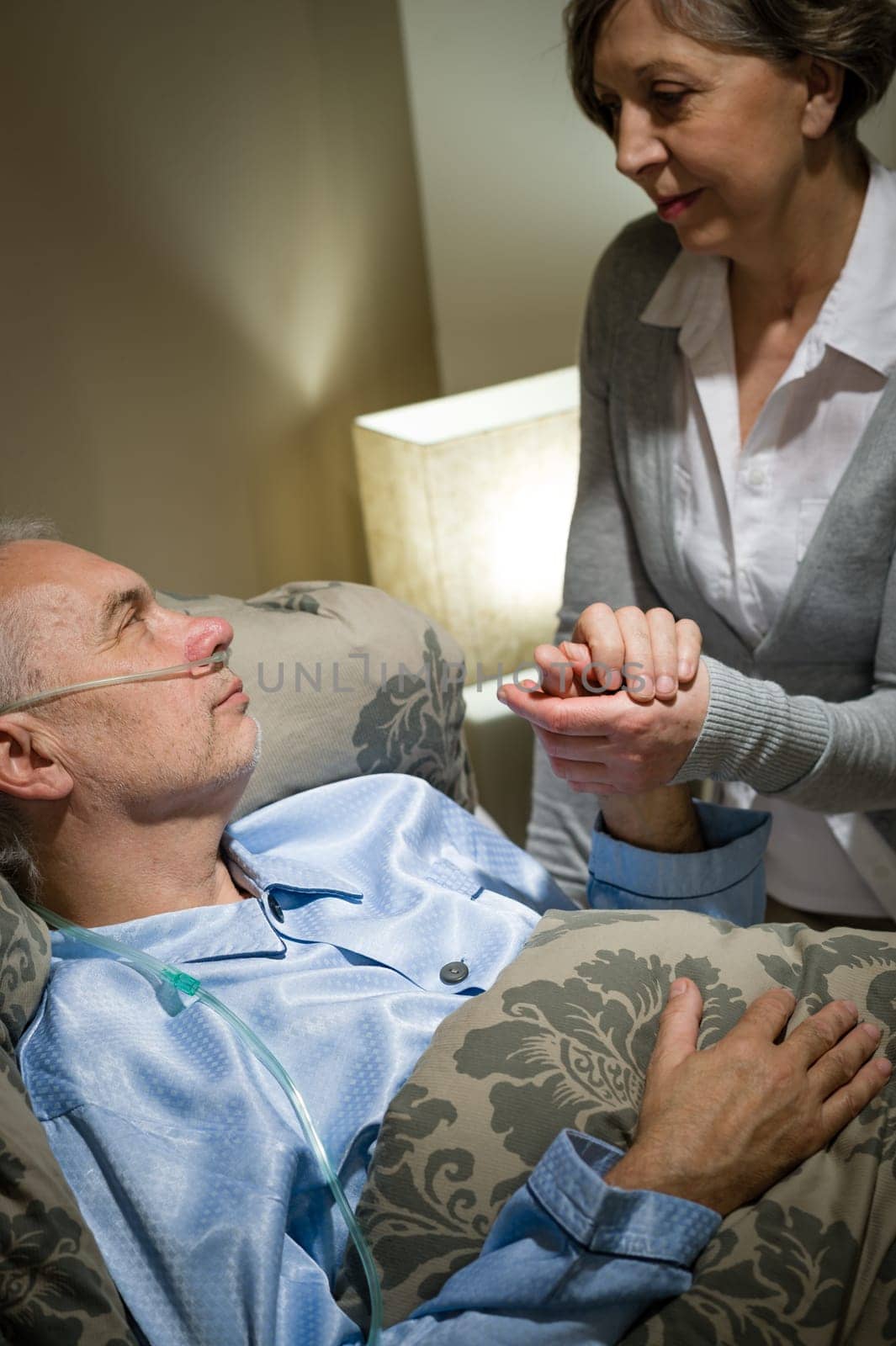Loving old woman taking care of her sick husband
