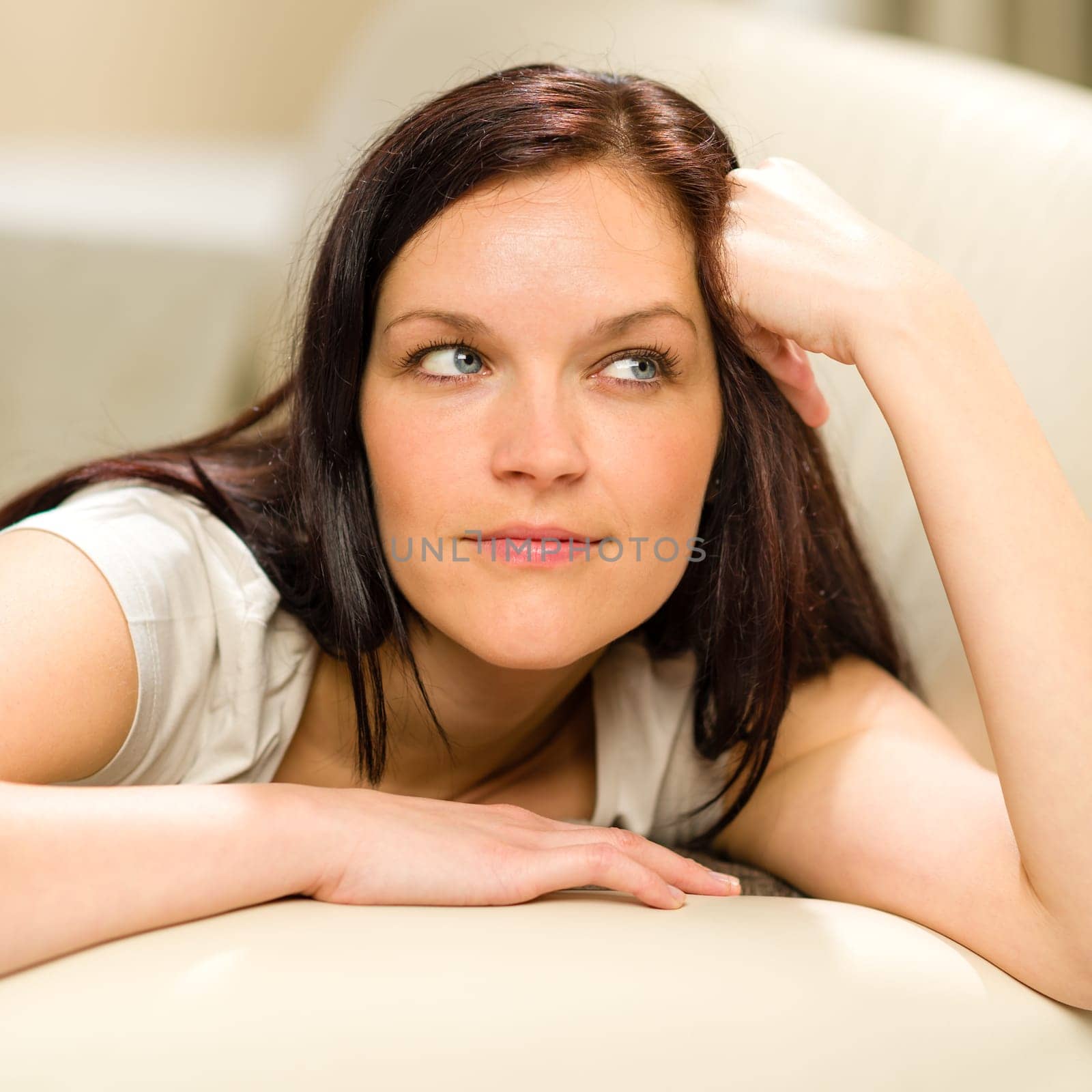 Thinking pensive woman lying in living room on sofa