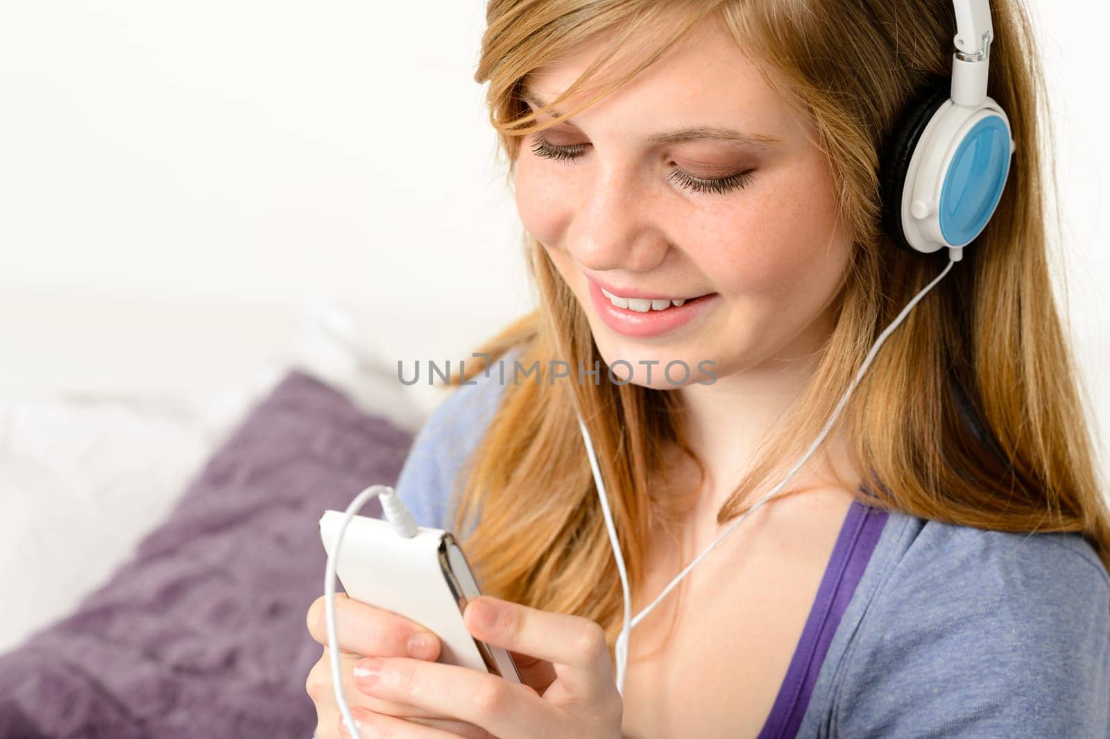 Fresh adolescent girl listening to music with mp3 player