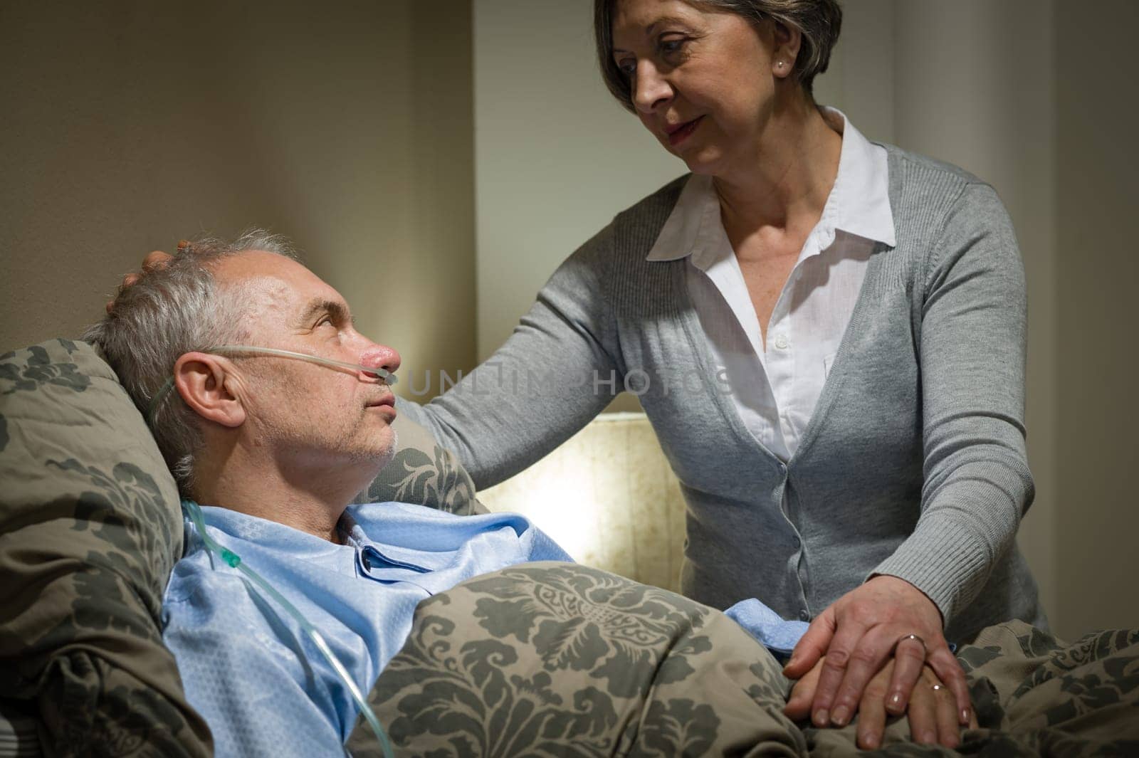 Worried senior woman caring with sick husband in the bedroom