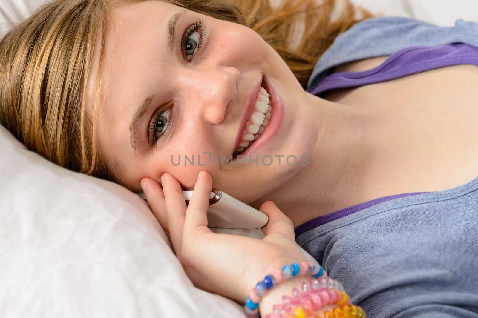 Portrait of a smiling teenager girl talking on her phone
