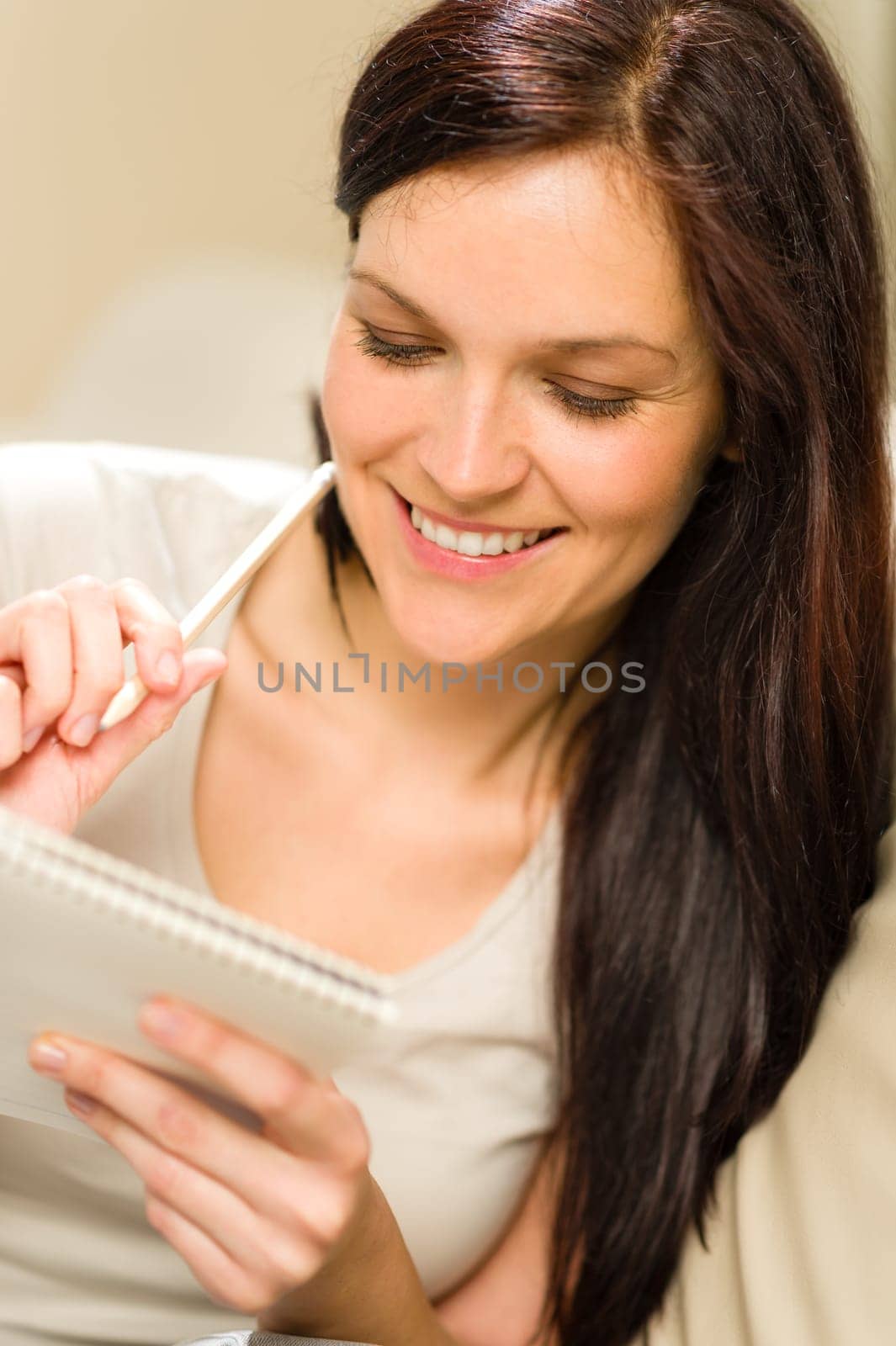 Young relaxed woman writing her diary