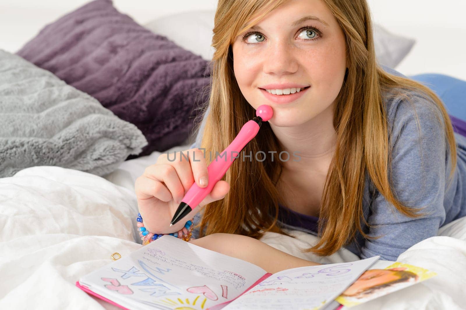 Daydreaming teenager girl writing her journal about a boy
