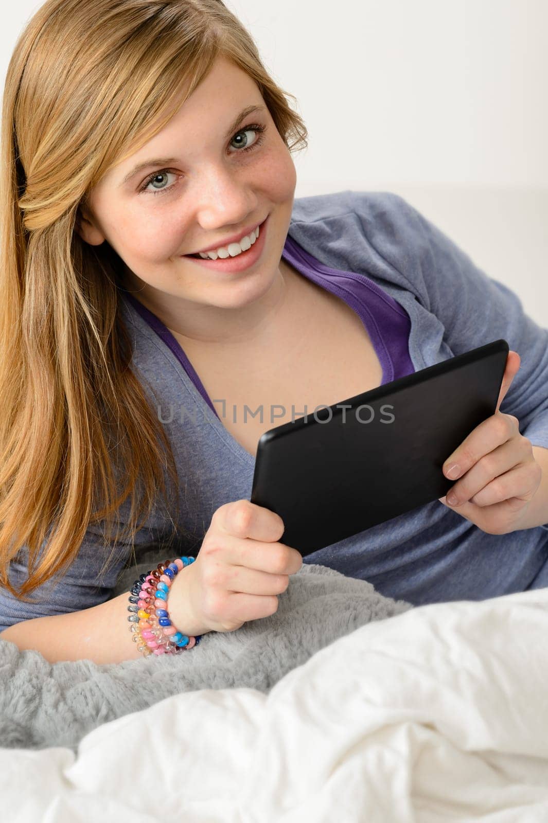 Happy young girl using digital tablet for studying