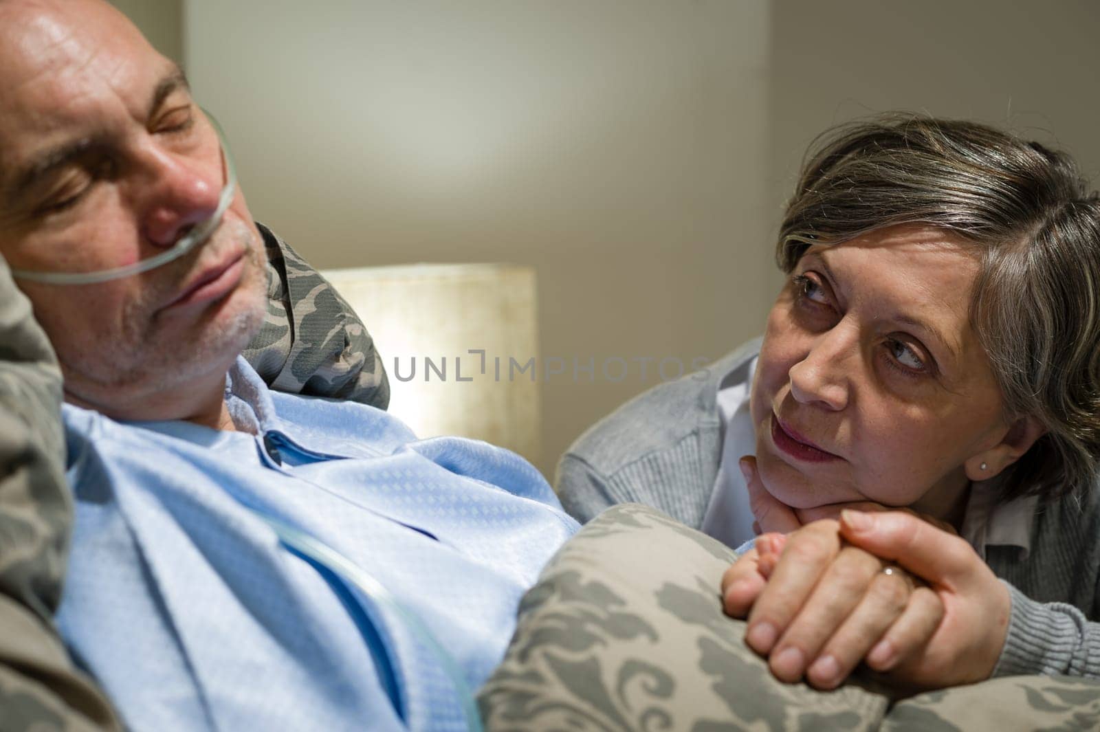 Anxious old woman taking care of sick husband