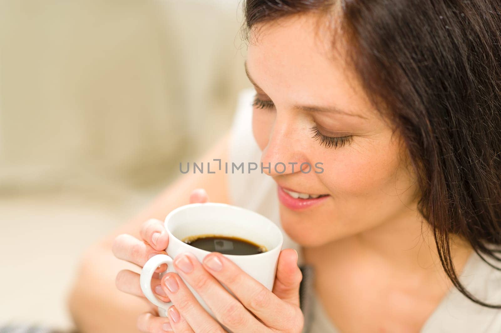 Cute woman holding cup of hot refreshing coffee