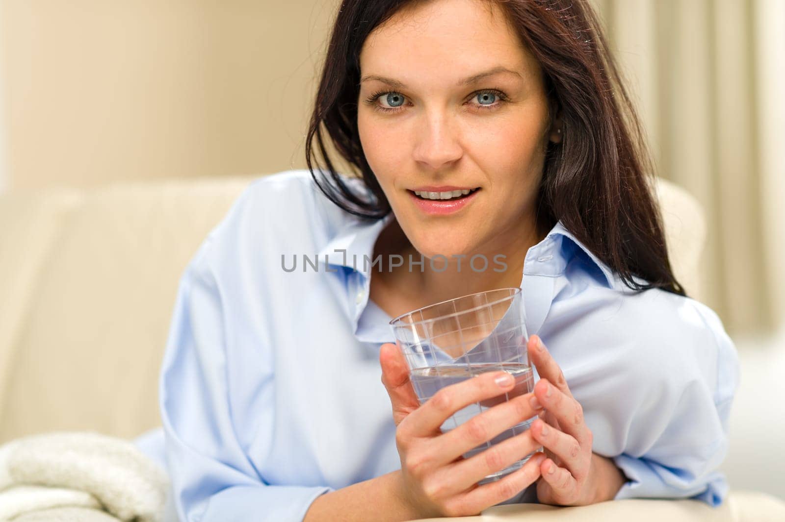 Portrait of woman leaning with glass of fresh water