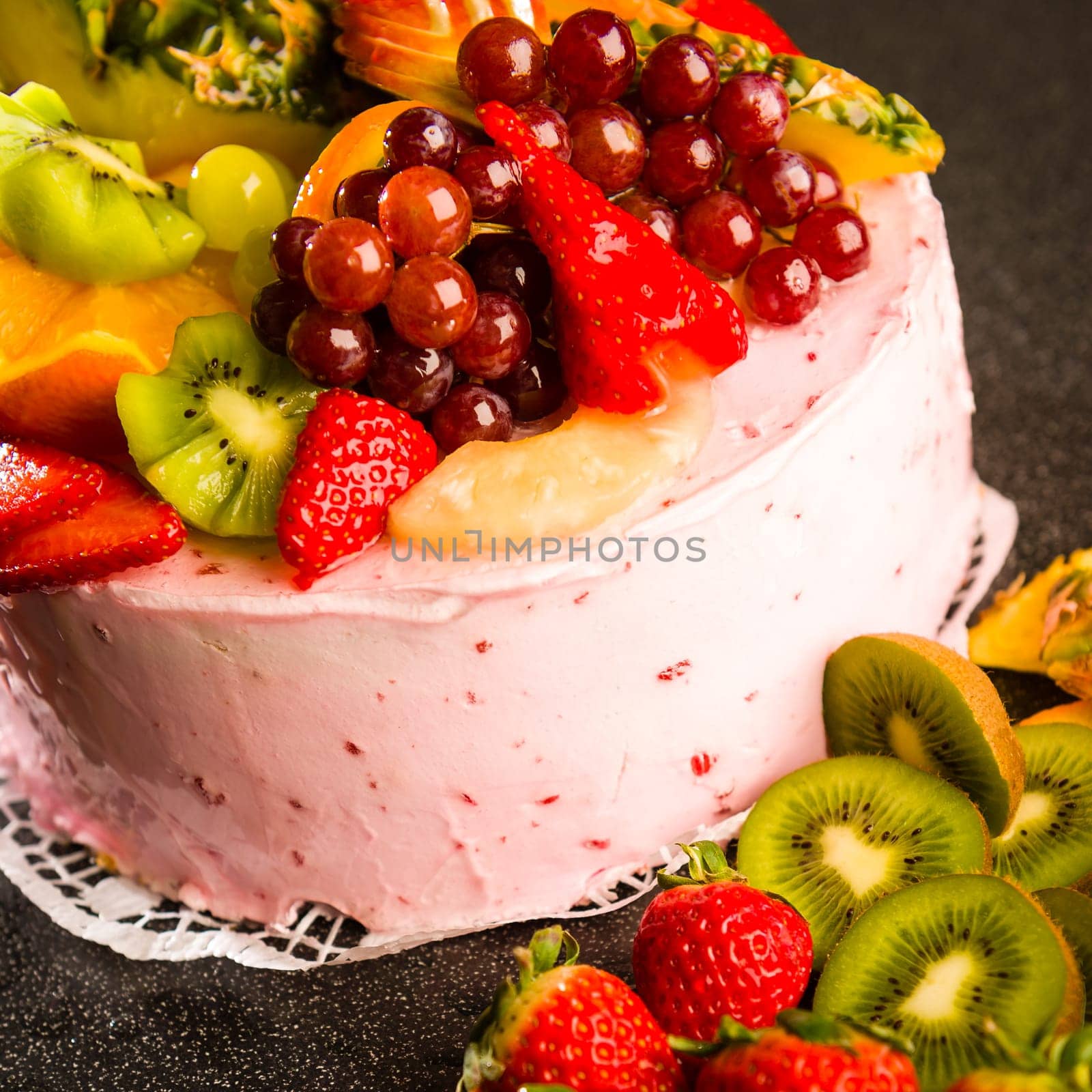 Fruit cake with cream coating and fresh fruits topping
