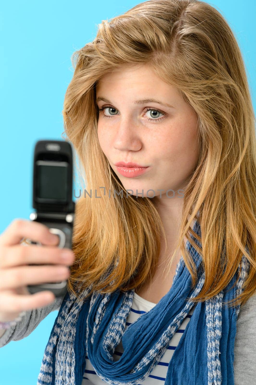 Young girl taking picture of herself with mobile phone
