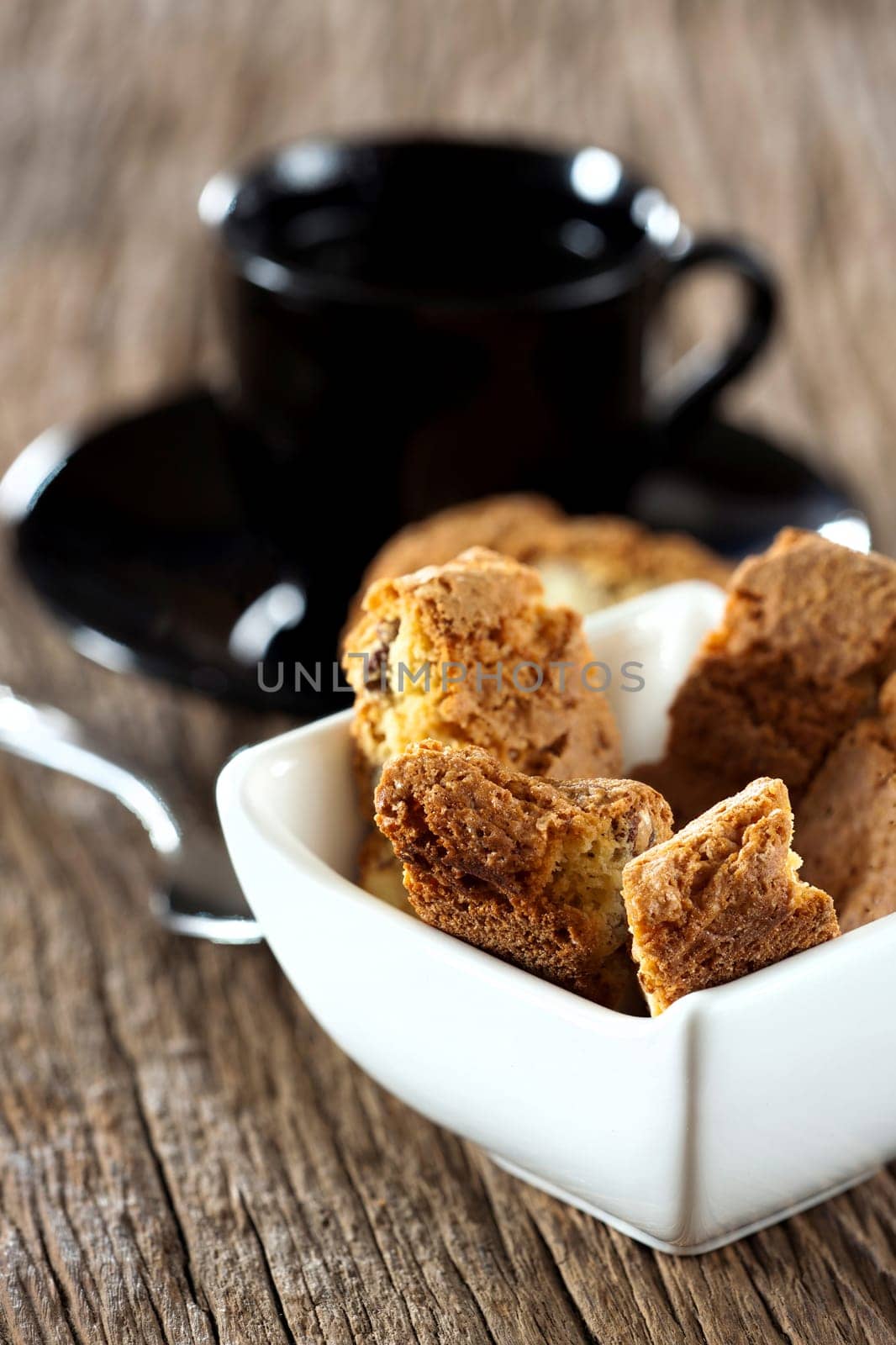 Fine cantuccini pastry in a small bowl on a wooden surface
