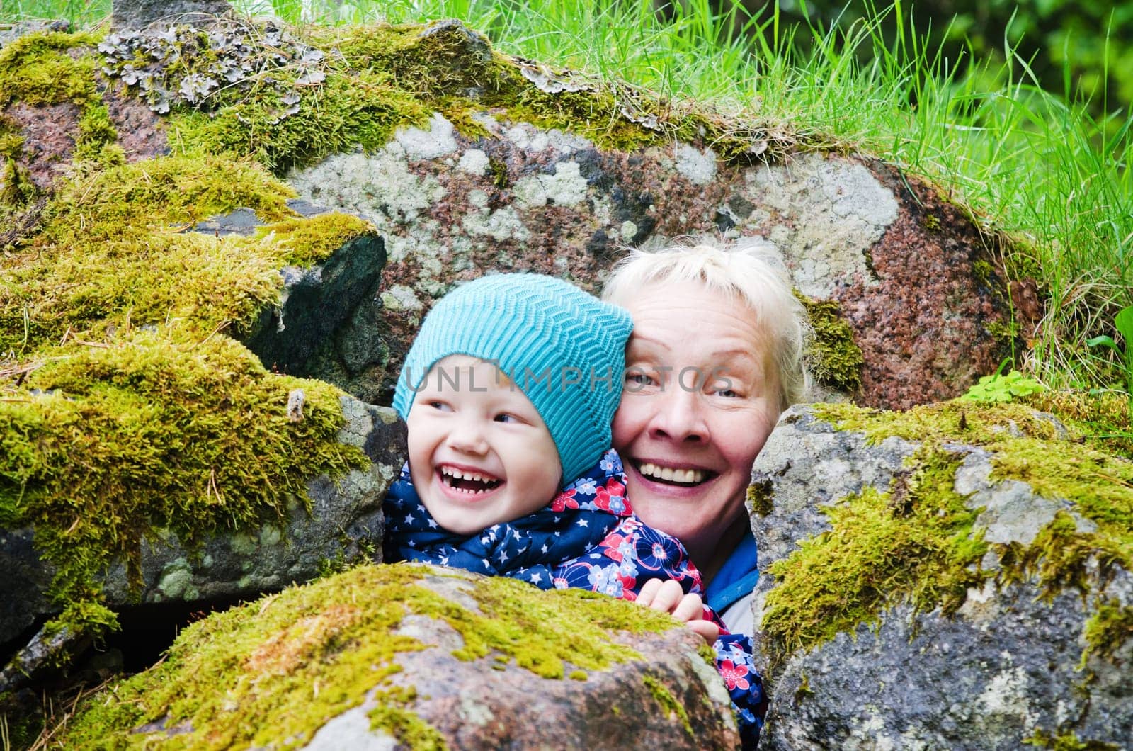 Grandmother with granddaughter hide among stones
