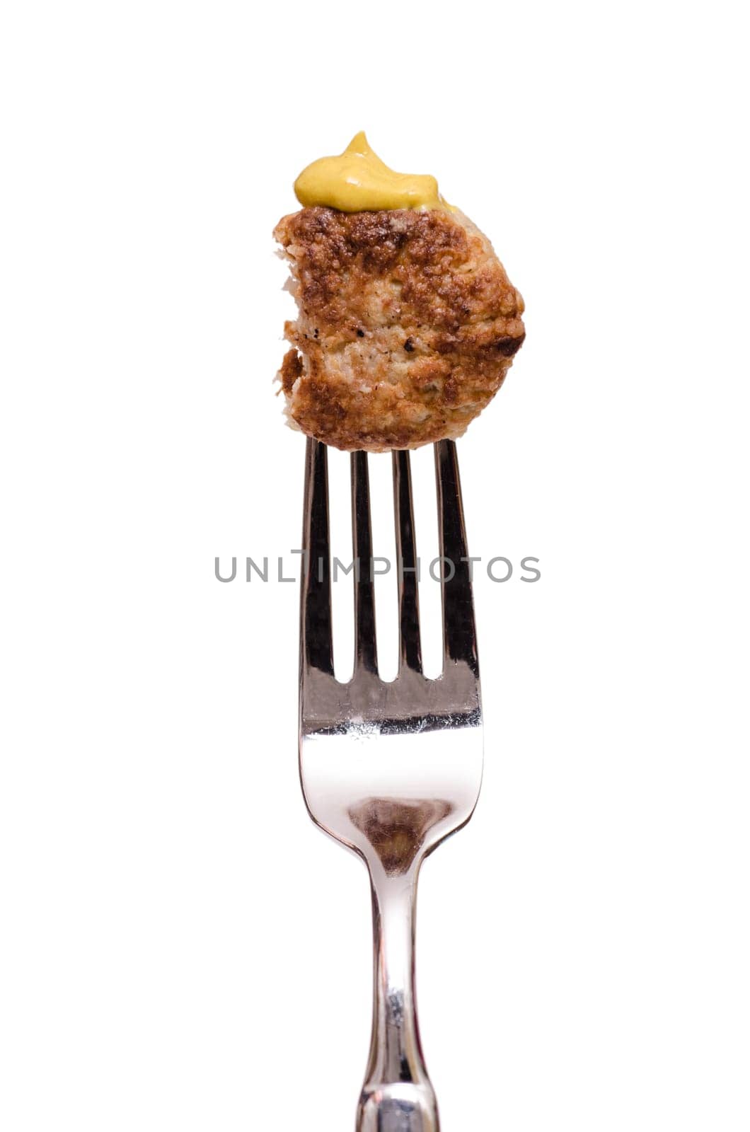 Bited meatball with mustard on a fork