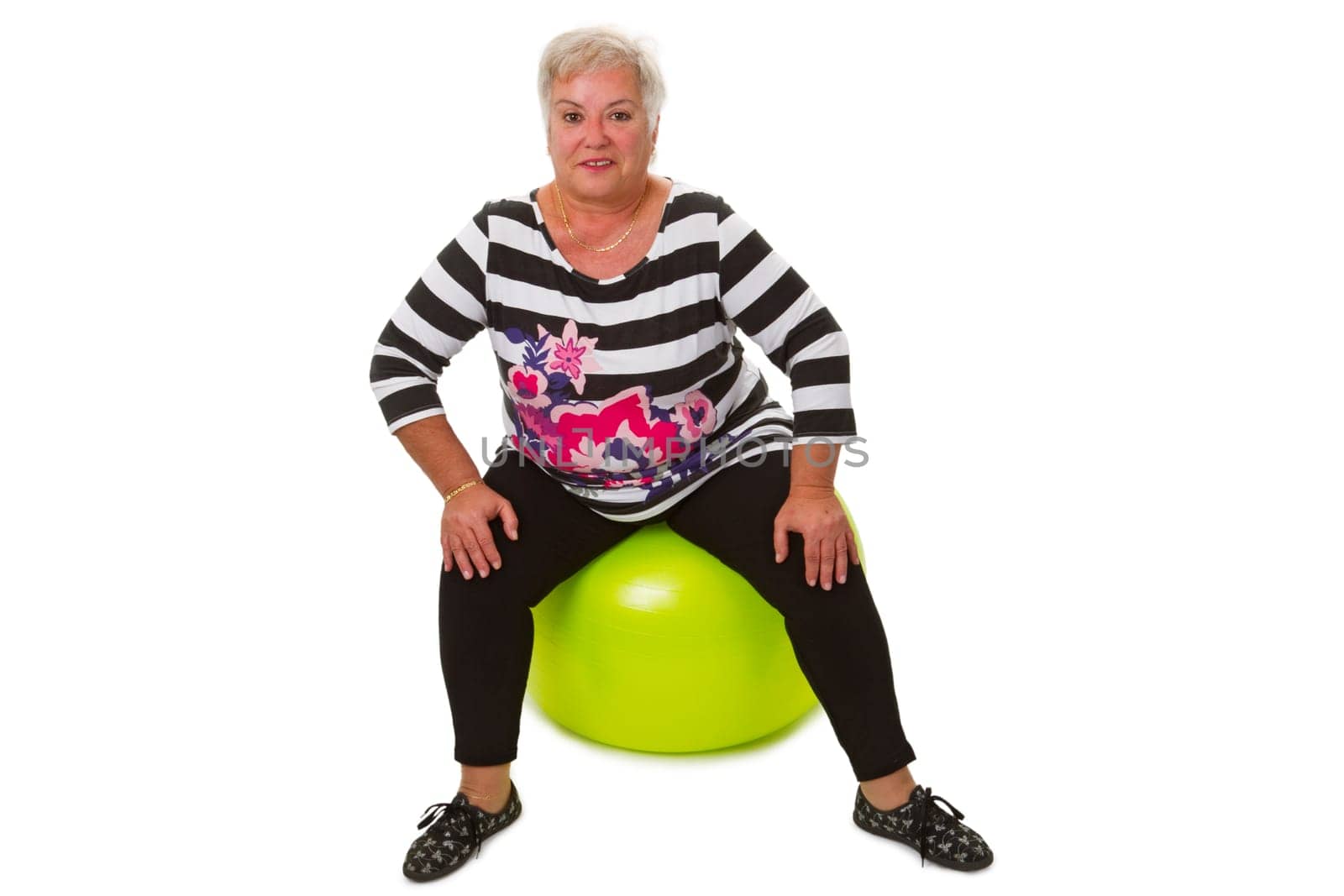 Senior citizen sits on gymnastics ball - released on a white background