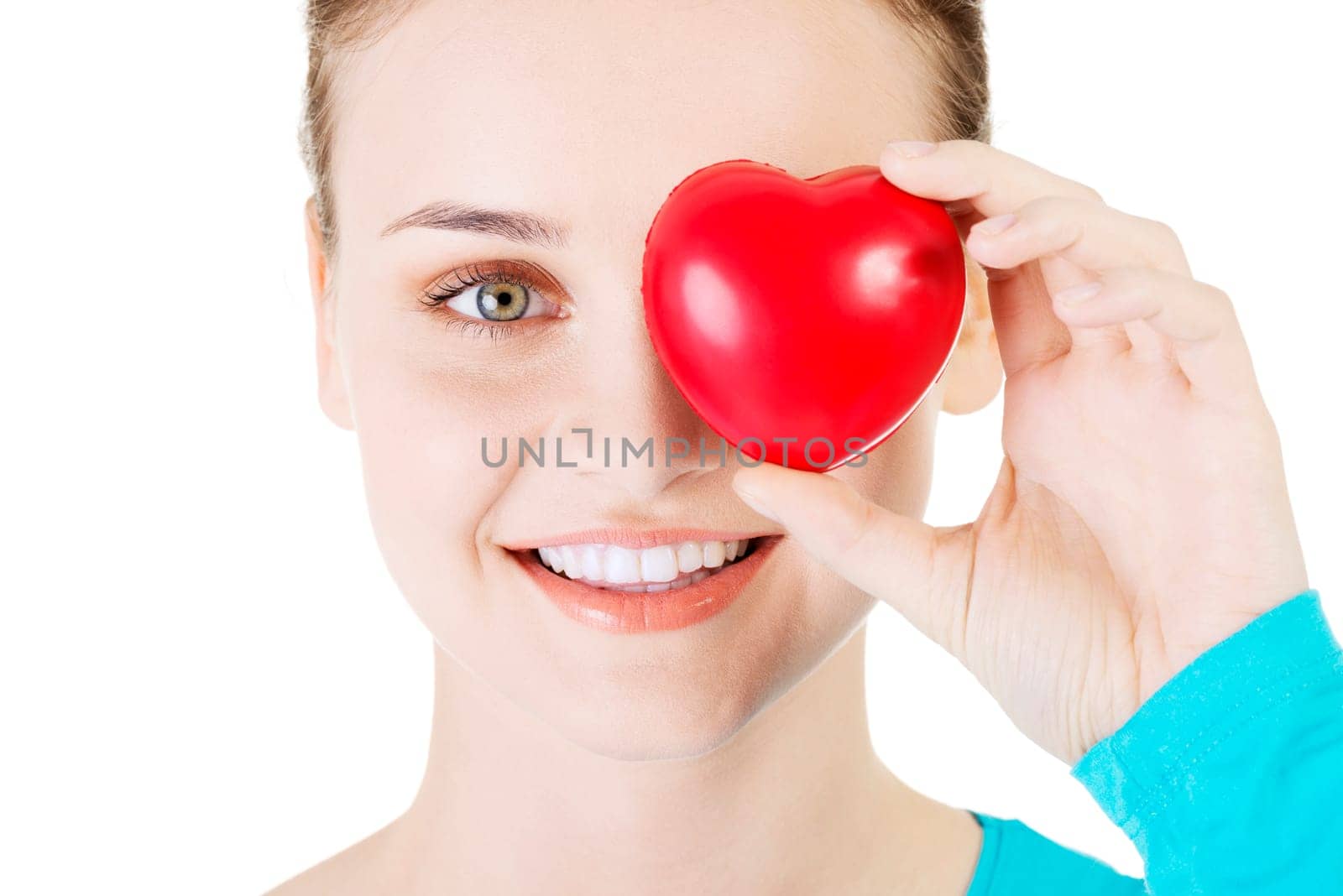 pretty girl showing a red heart in her hand over white.