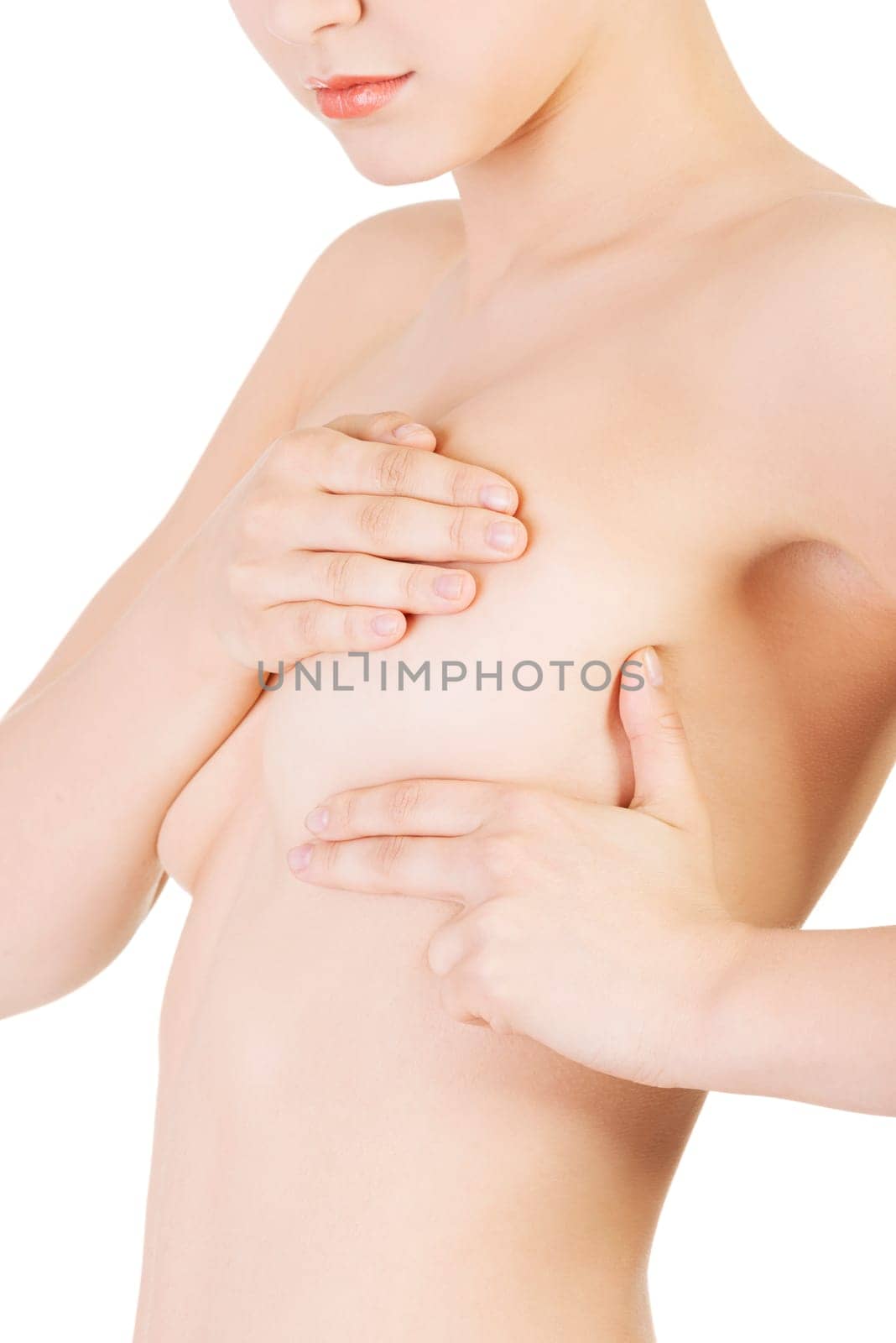 young caucasian adult woman examining her breast for lumps or signs of breast cancer