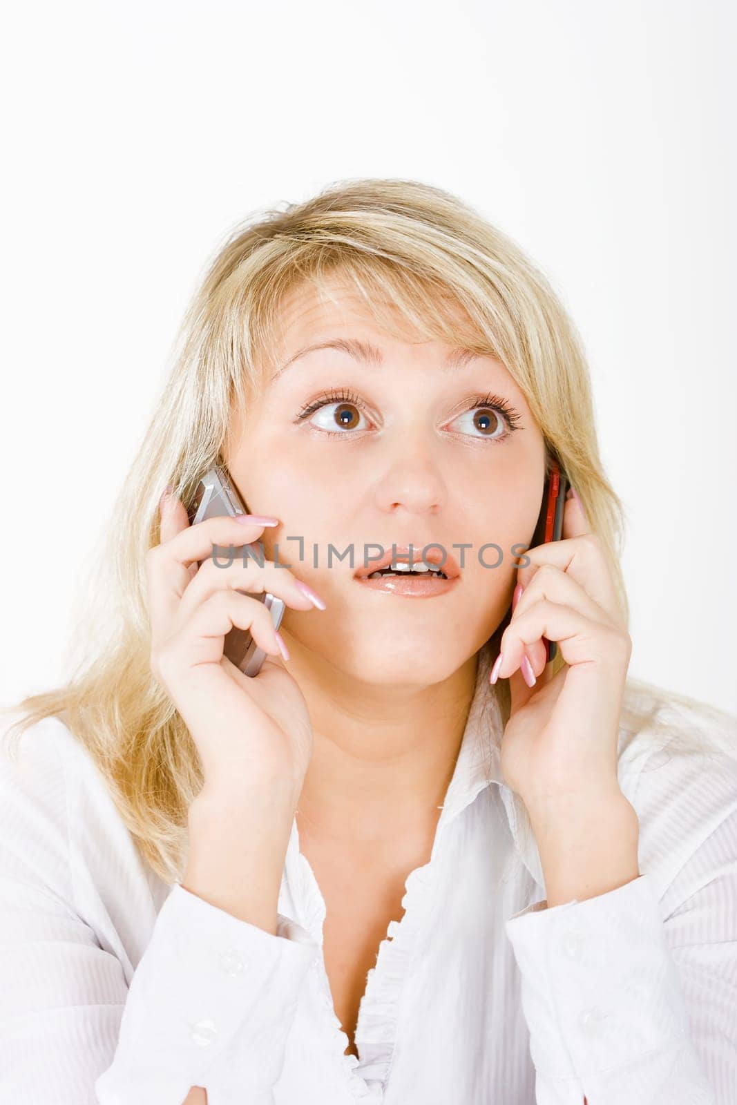 surprised blonde with two mobile phones on a white background