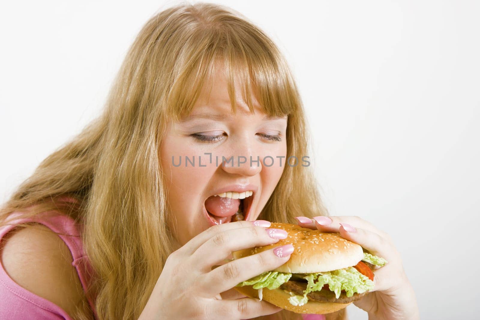 Hungry blonde and a delicious hamburger on a white background