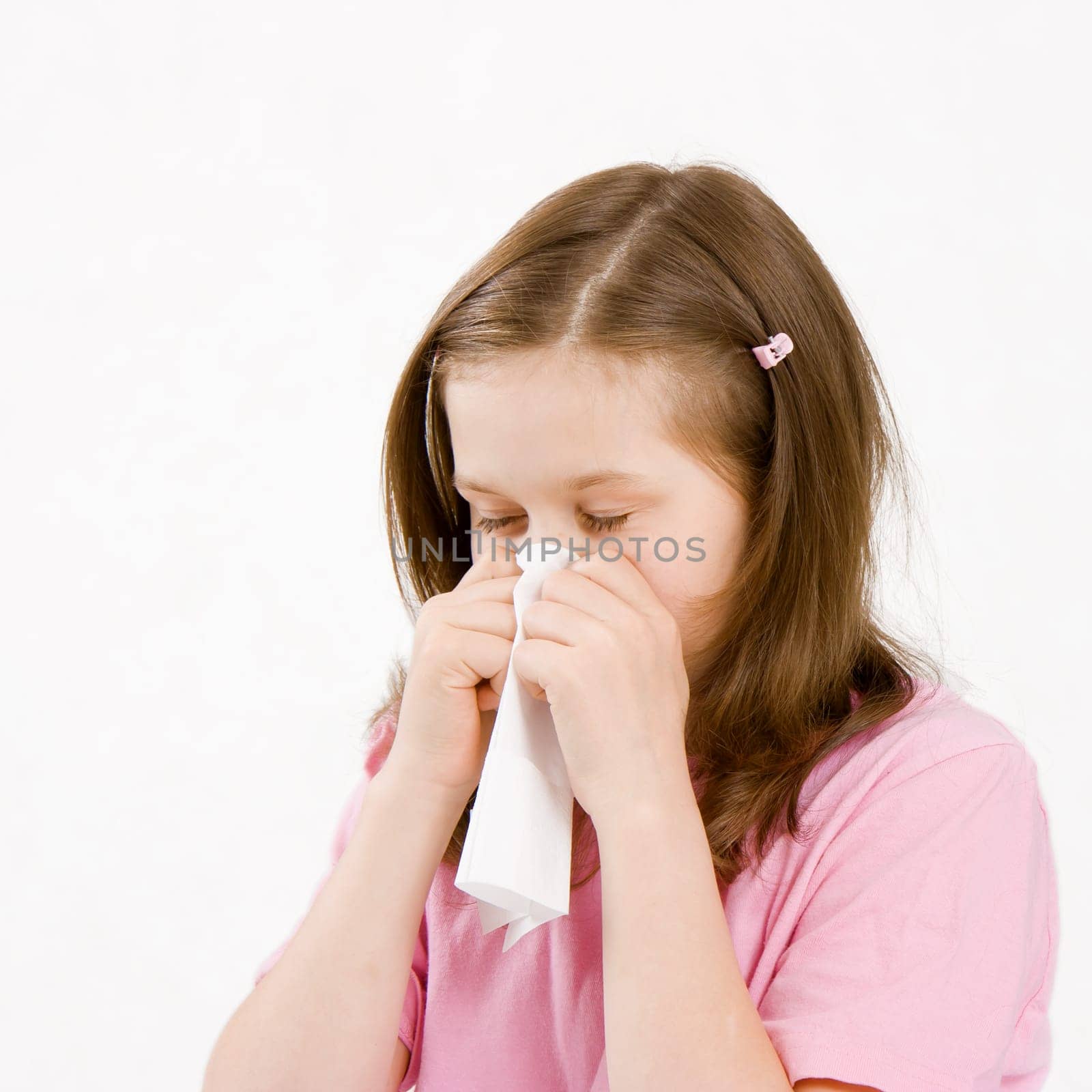 sick girl with a paper handkerchief on a white background