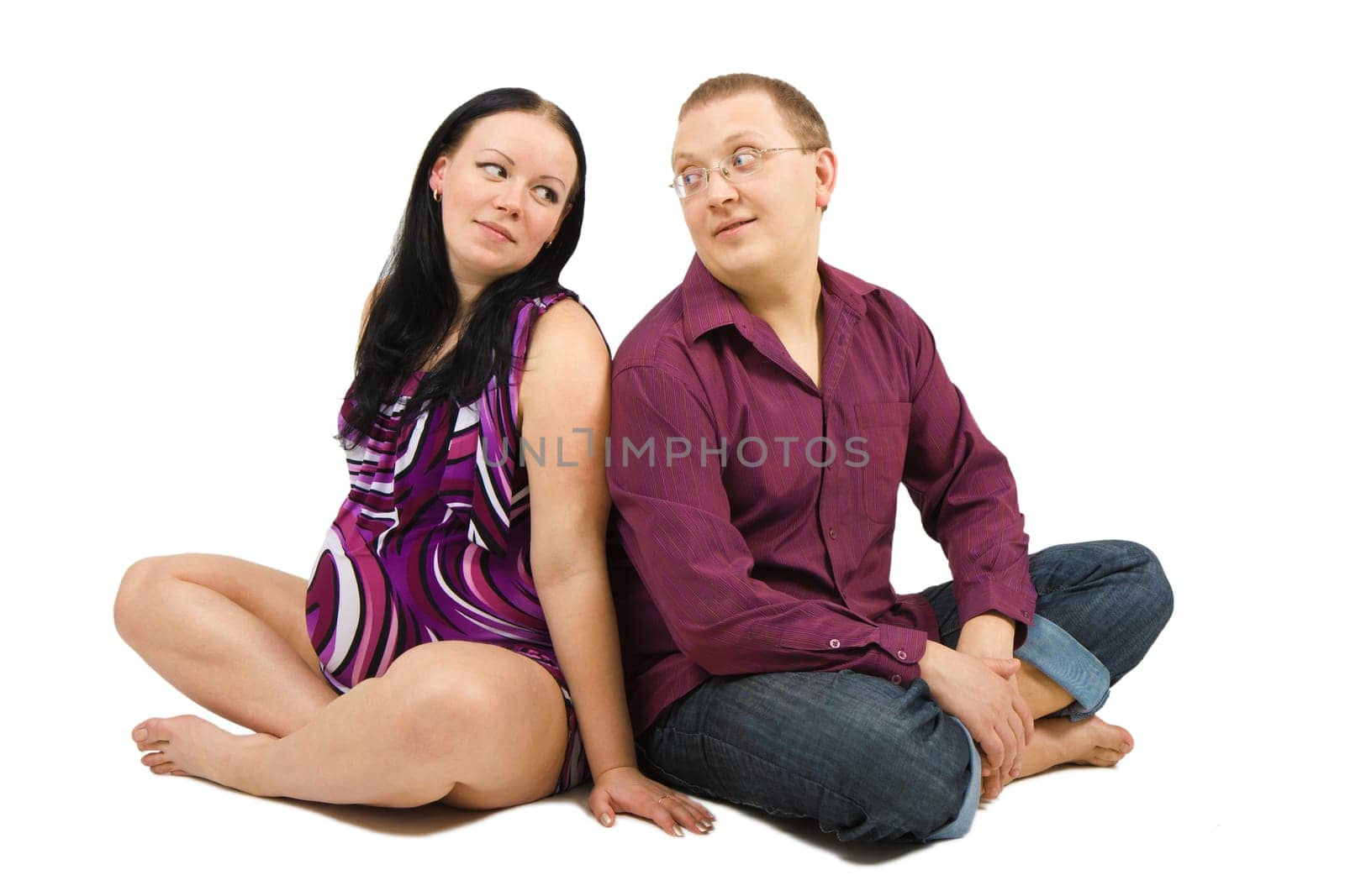 young couple awaiting the birth of a child sitting on the floor on a white background
