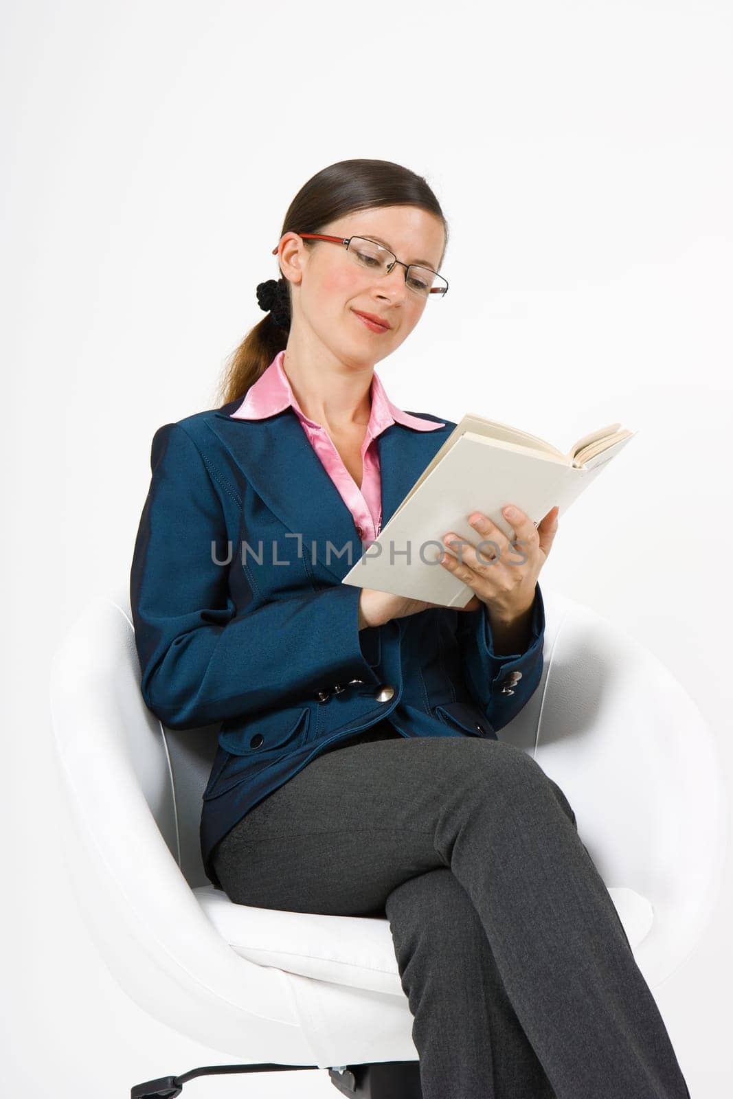 girl with glasses sitting in a chair reading a book