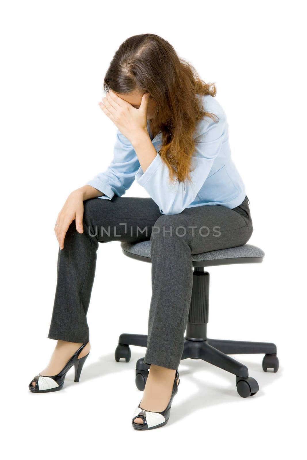 young girl sitting on a chair arm covering her face