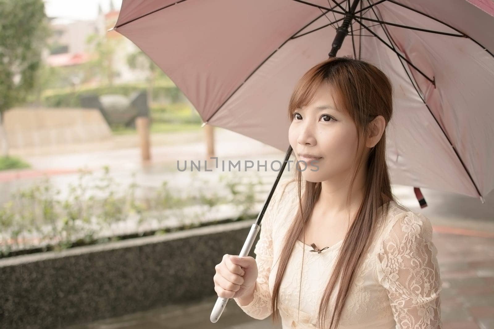Asian beauty in raining day hold an umbrella in outside, Taipei, Taiwan.