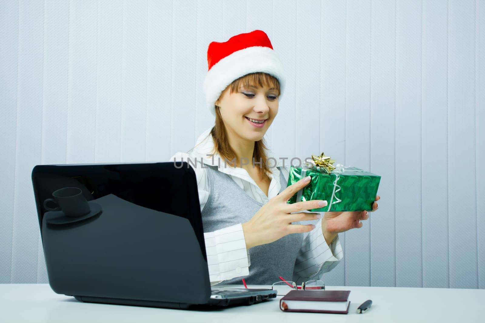 happy business woman in Santa hat with a gift at the office