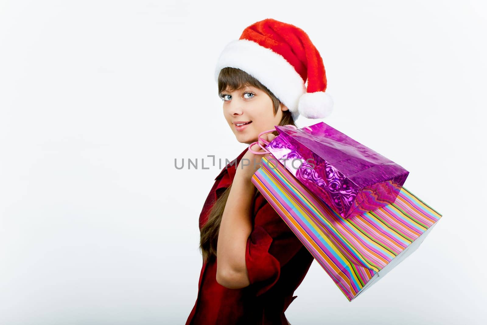 a beautiful young smiling girl in Santa hat with shopping