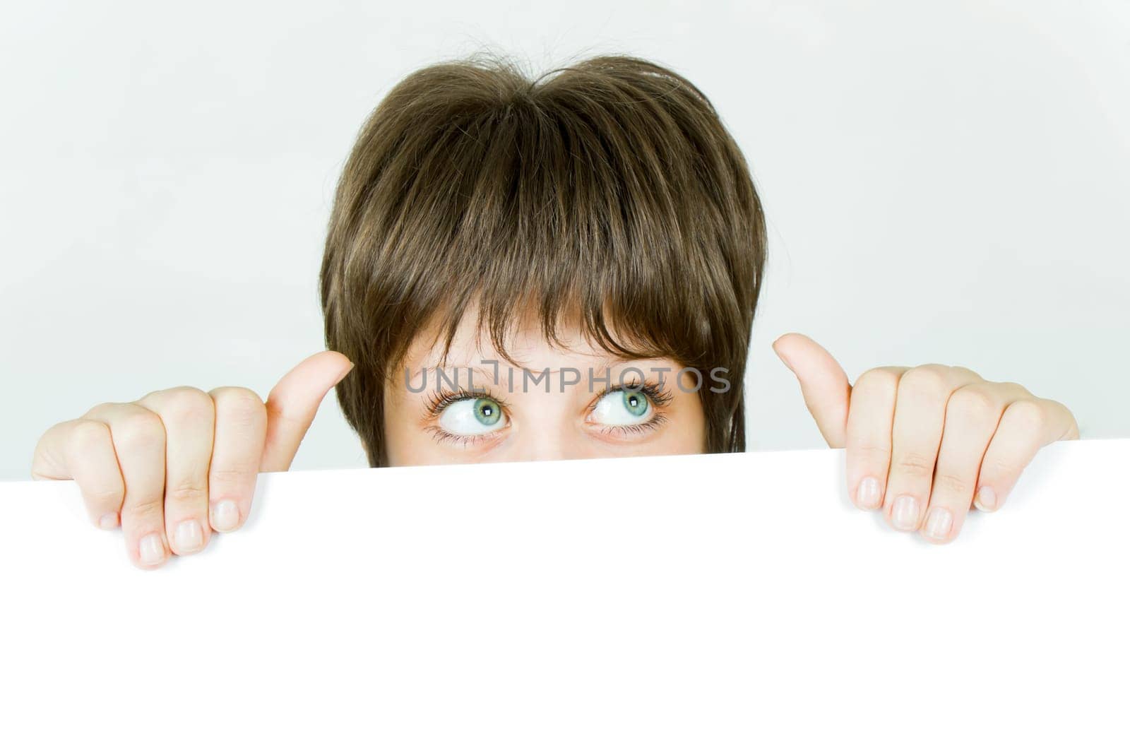 young girl hiding behind a white banner