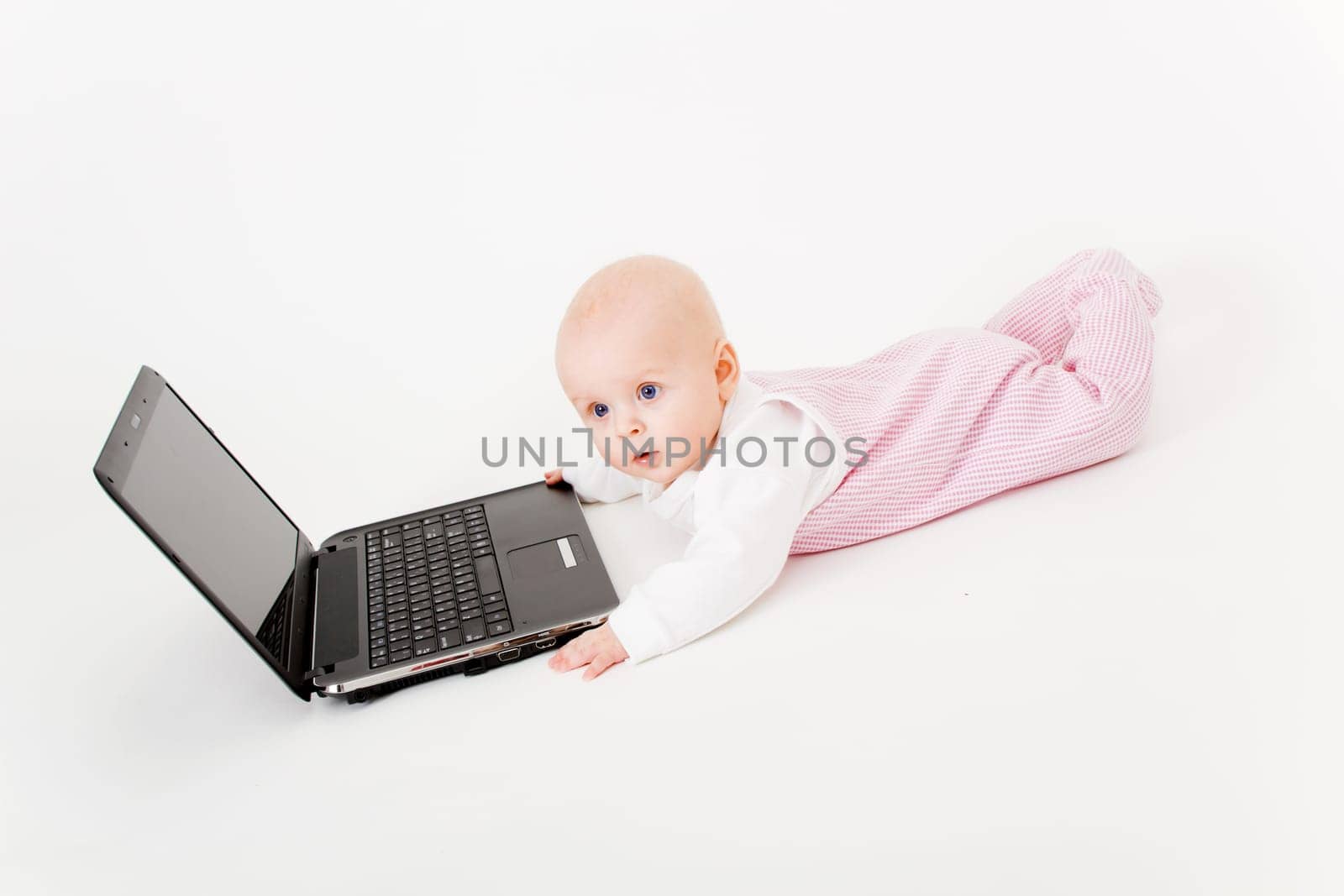 baby with laptop on a white background in studio
