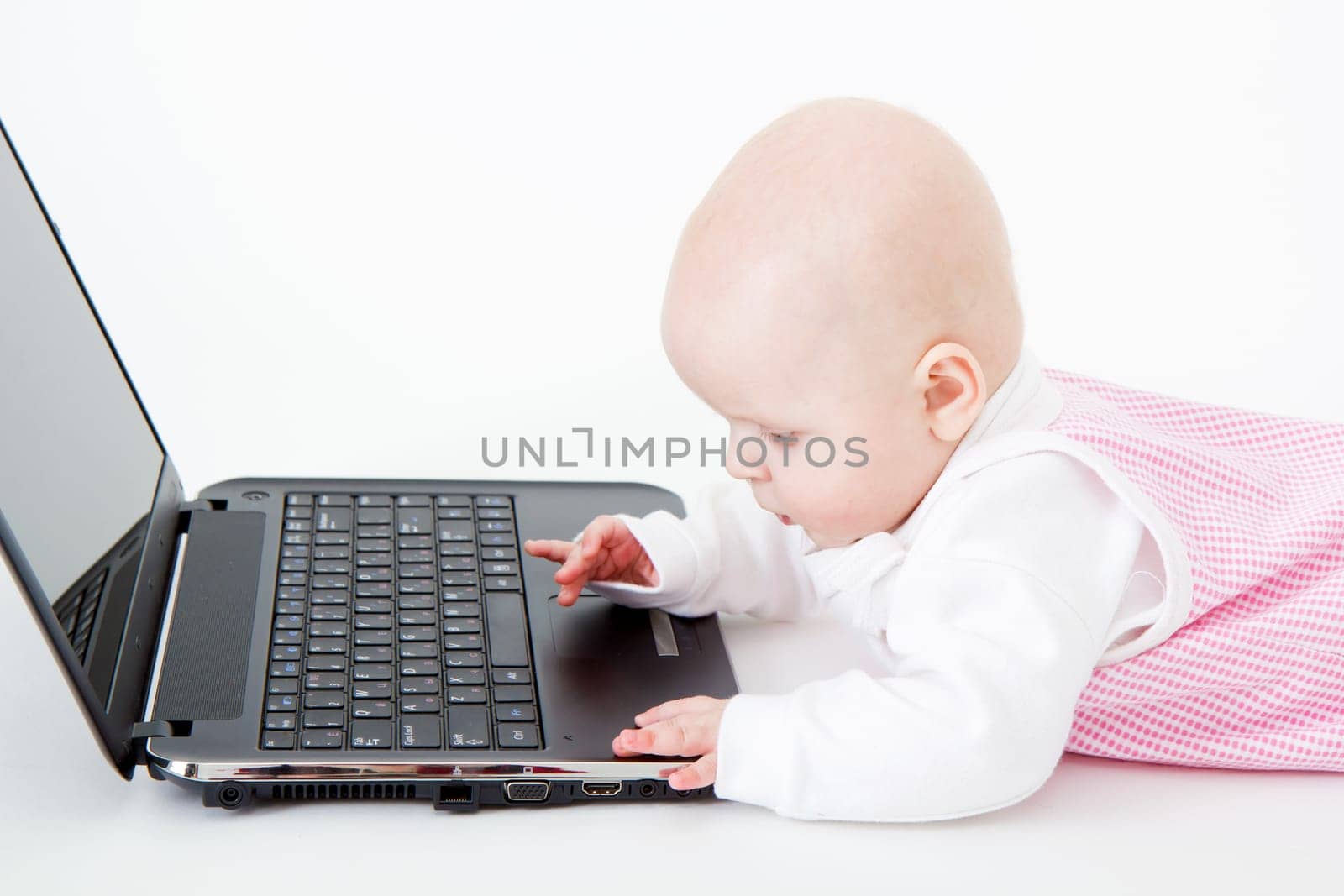 dressed the baby played with a laptop on a white background