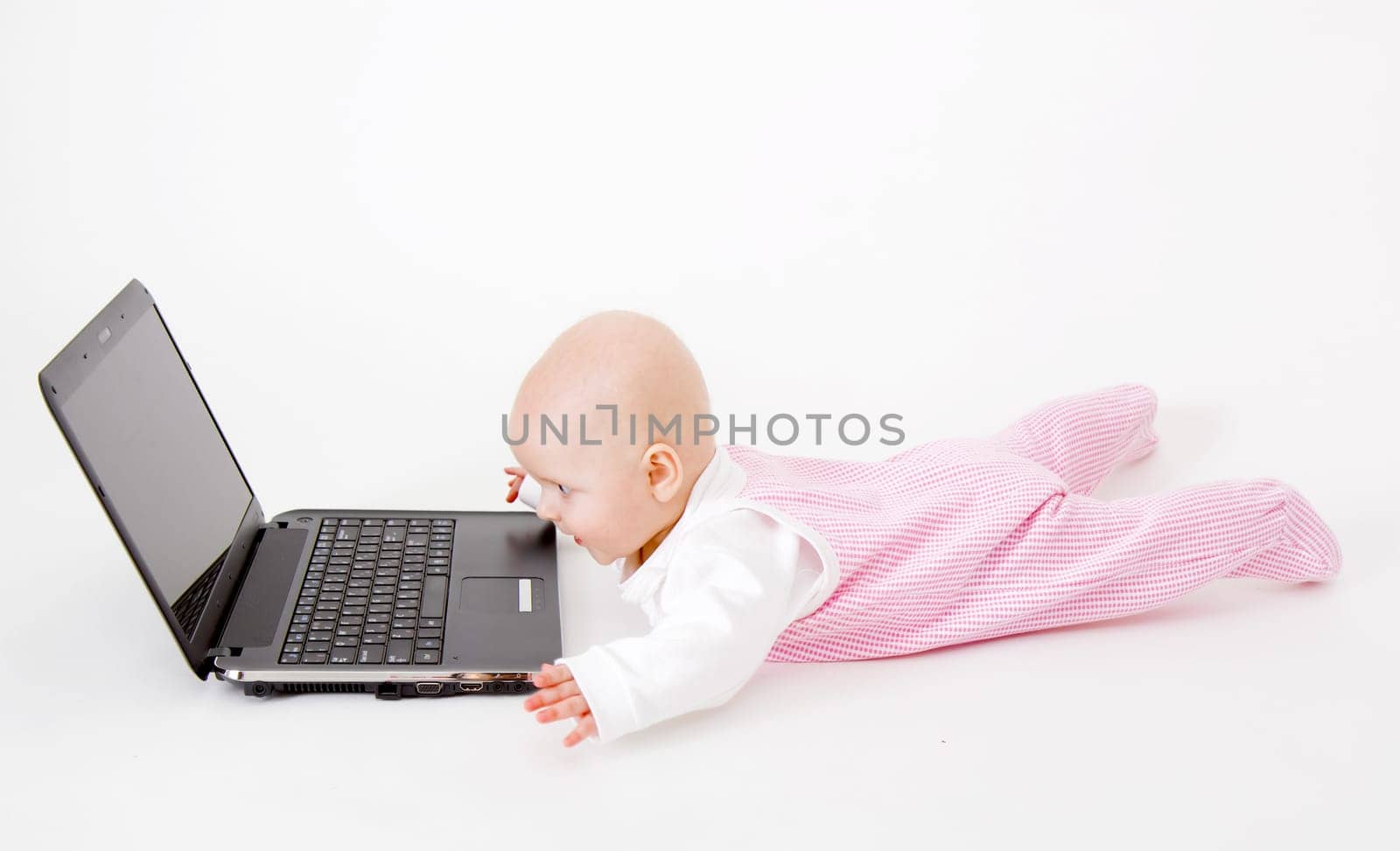 baby with laptop on a white background in studio