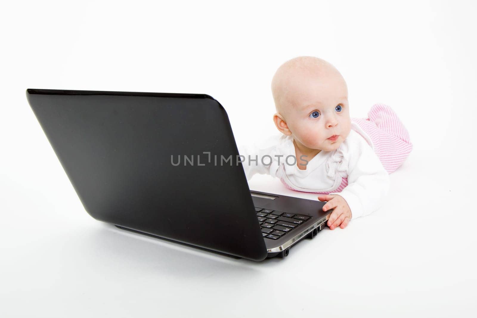 baby with laptop lying on a white background
