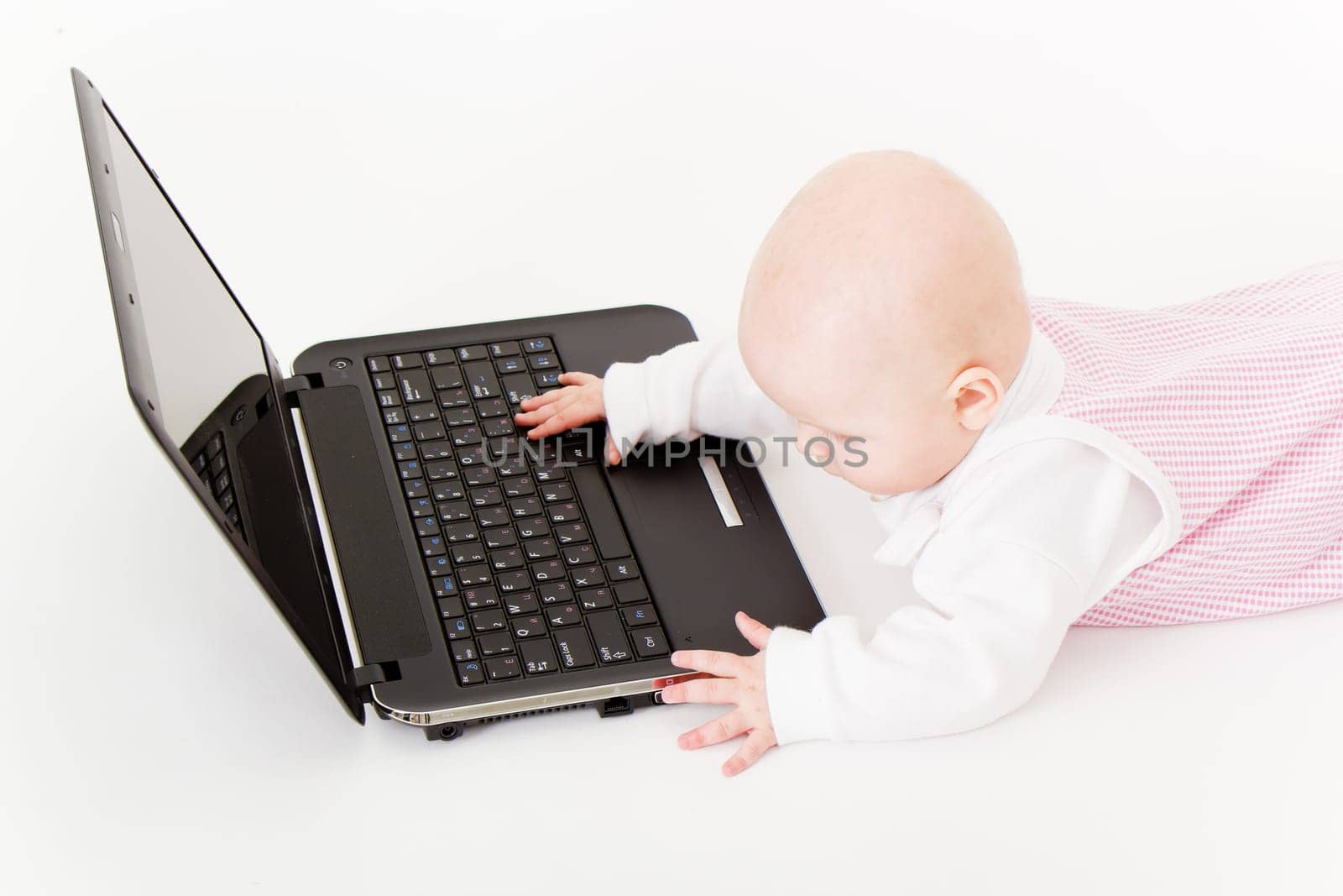 baby with laptop on a white background in studio