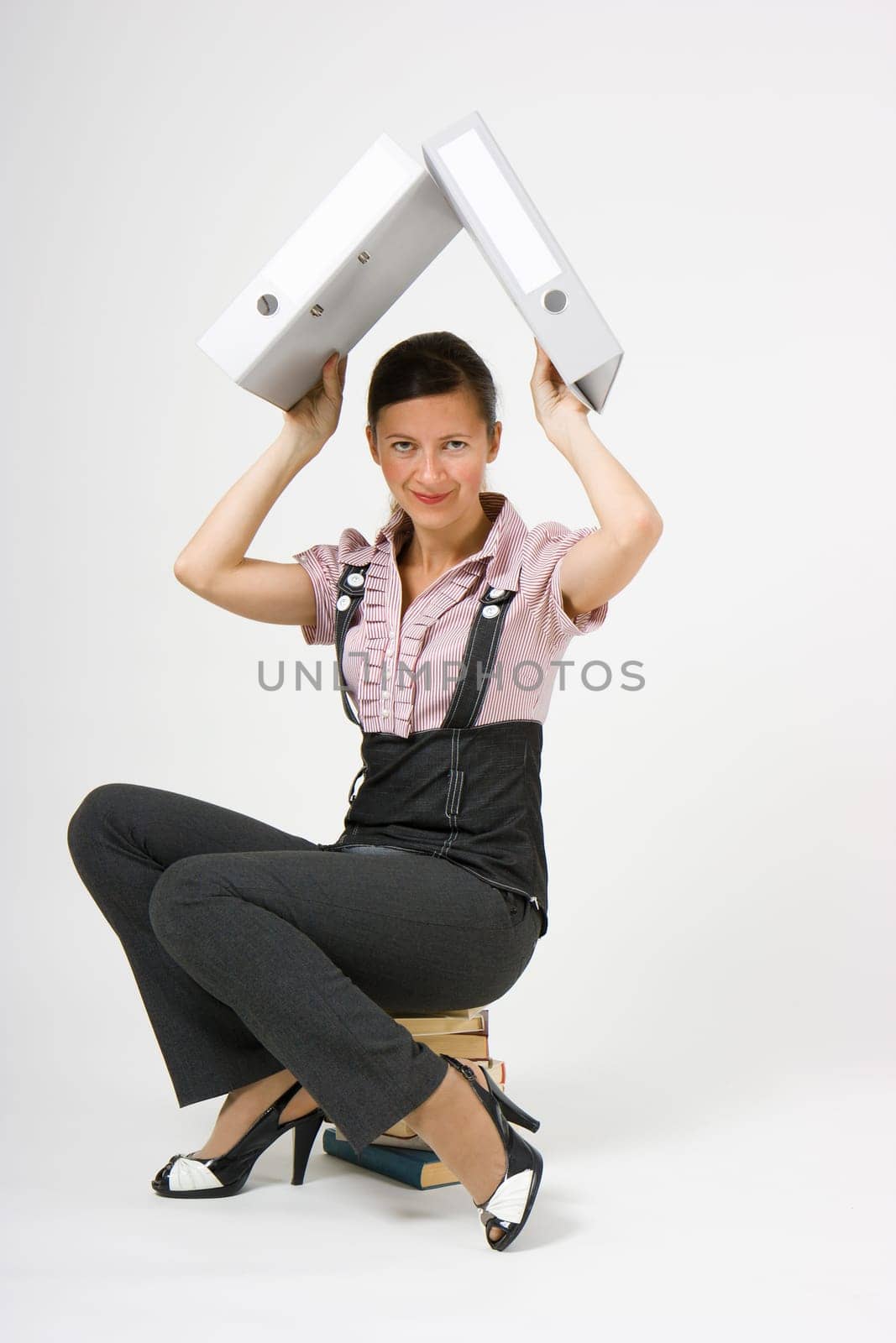 girl sitting on the books of hiding files on a light background