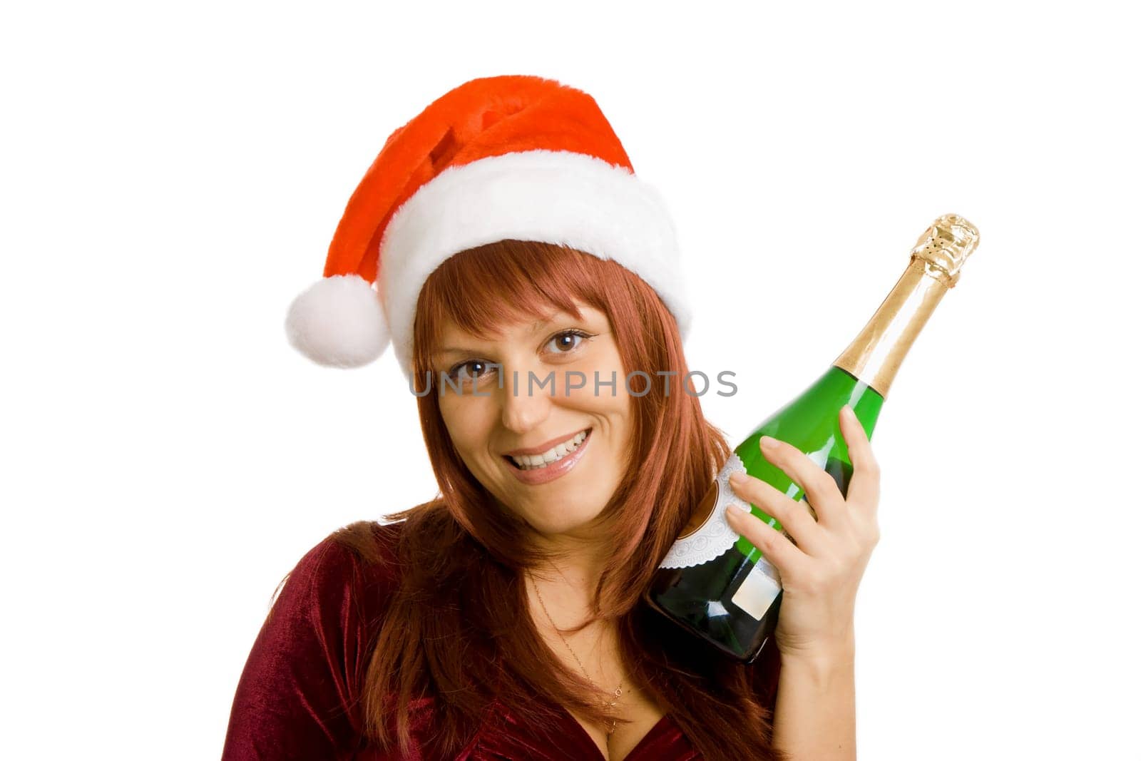 Smiling girl in a Christmas hat with a bottle of champagne in hand. White isolated background