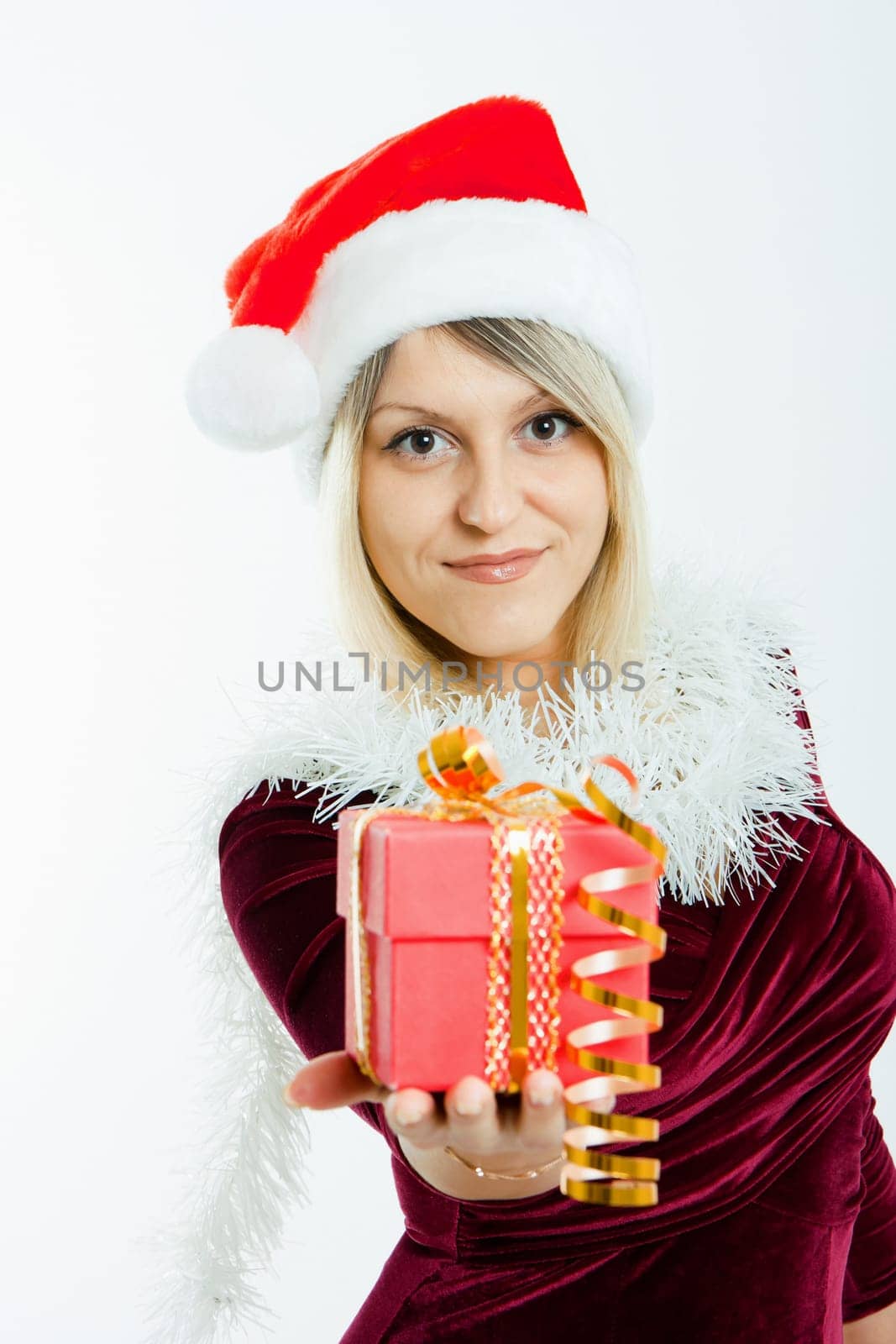 beautiful smiling blonde in a Christmas hat holding a small gift