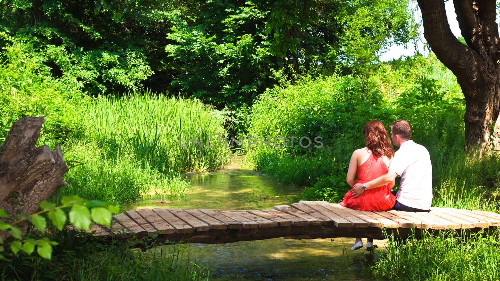 Young couple inlove sitting on a bridge