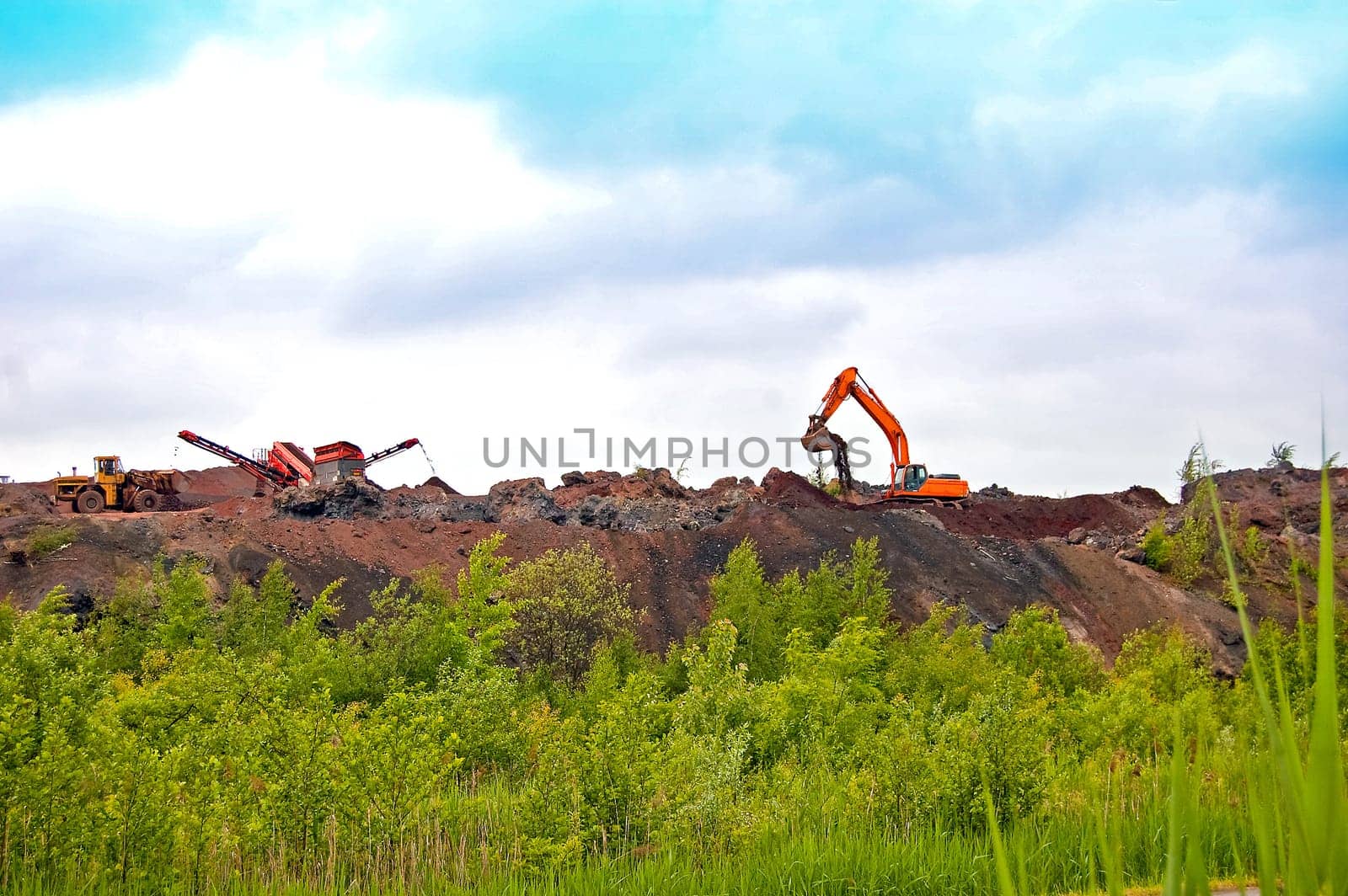heavy equipment working on the construction of the road on the embankment