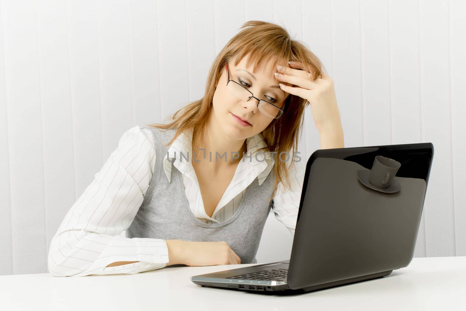 tired worker in the office. Disheveled girl with laptop