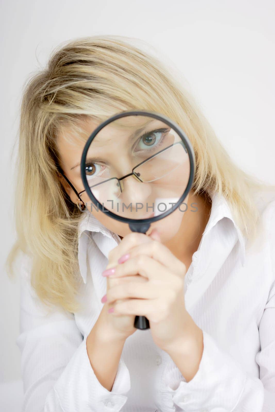 girl with a magnifying glass on a light background