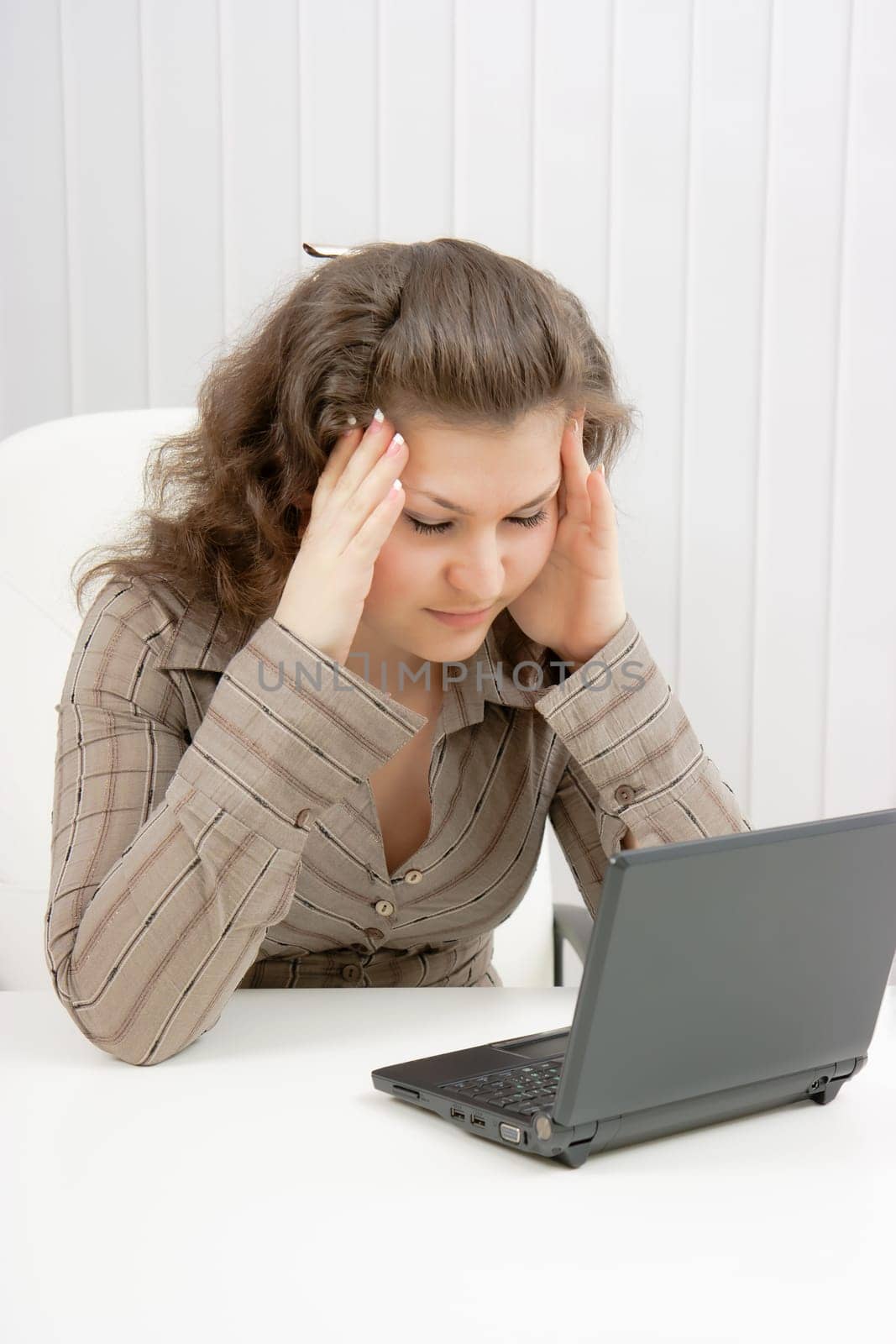 girl with laptop suffers from headaches. Office