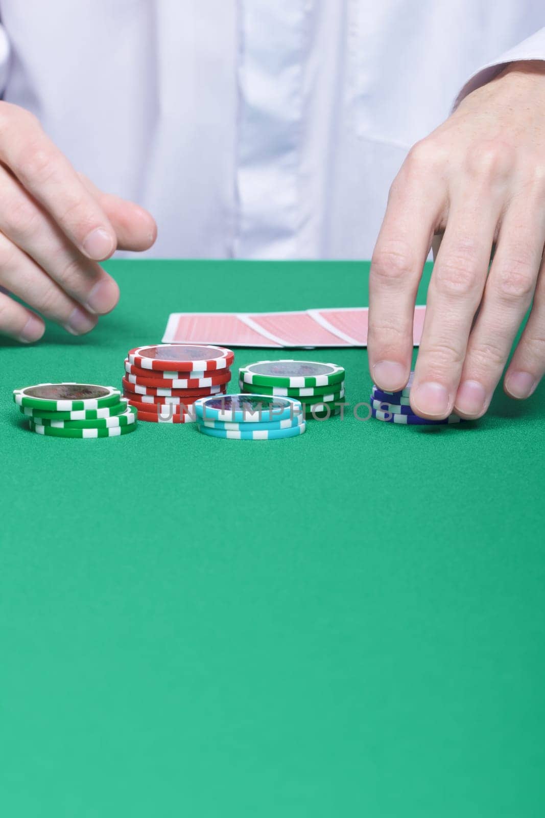 man's hand collects the chips with game table