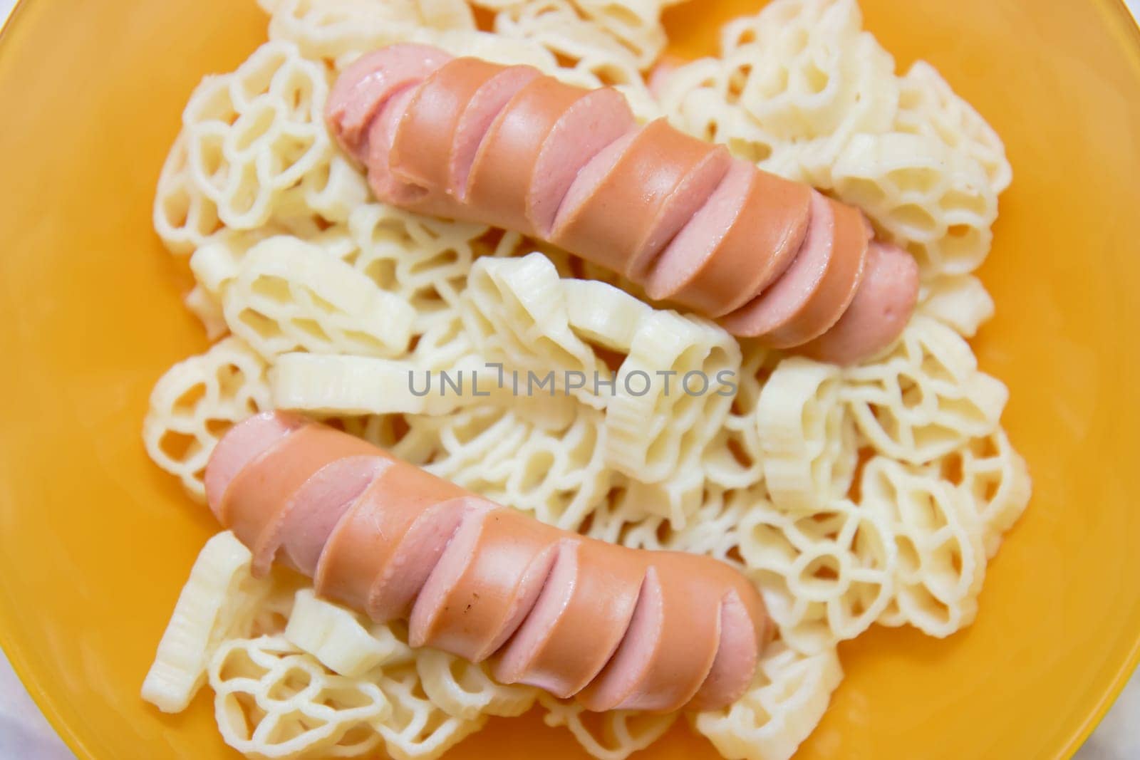 homemade sausage with pasta on the yellow plate