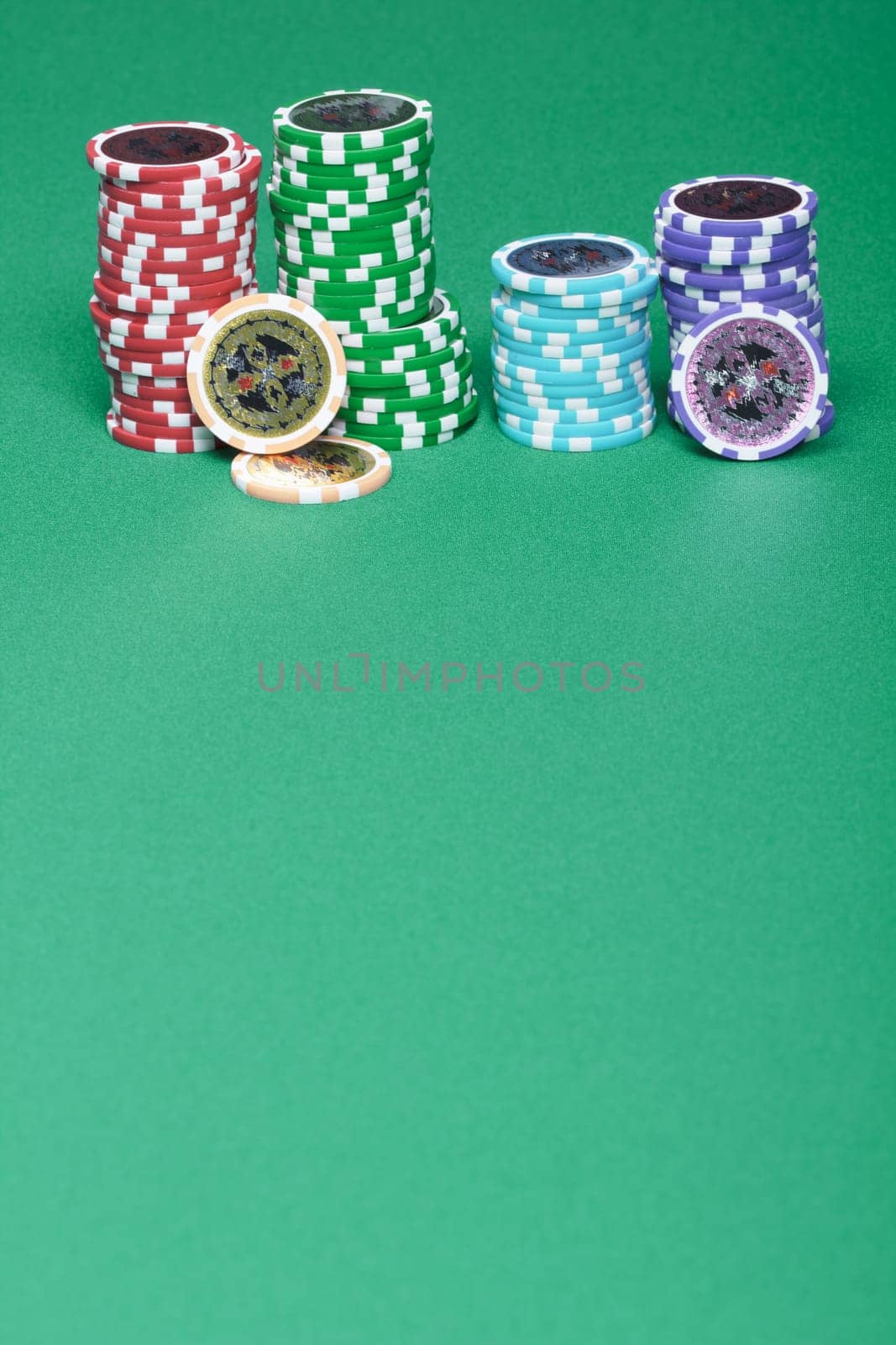A stack of chips on a green playing a gambling table in a casino