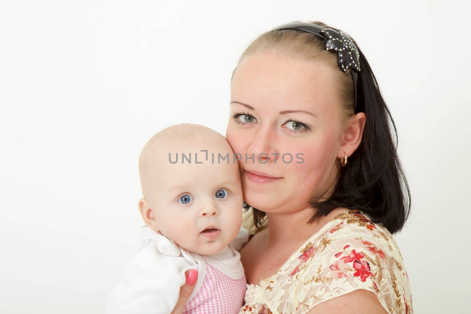 infant in the arms of the mother on a light background