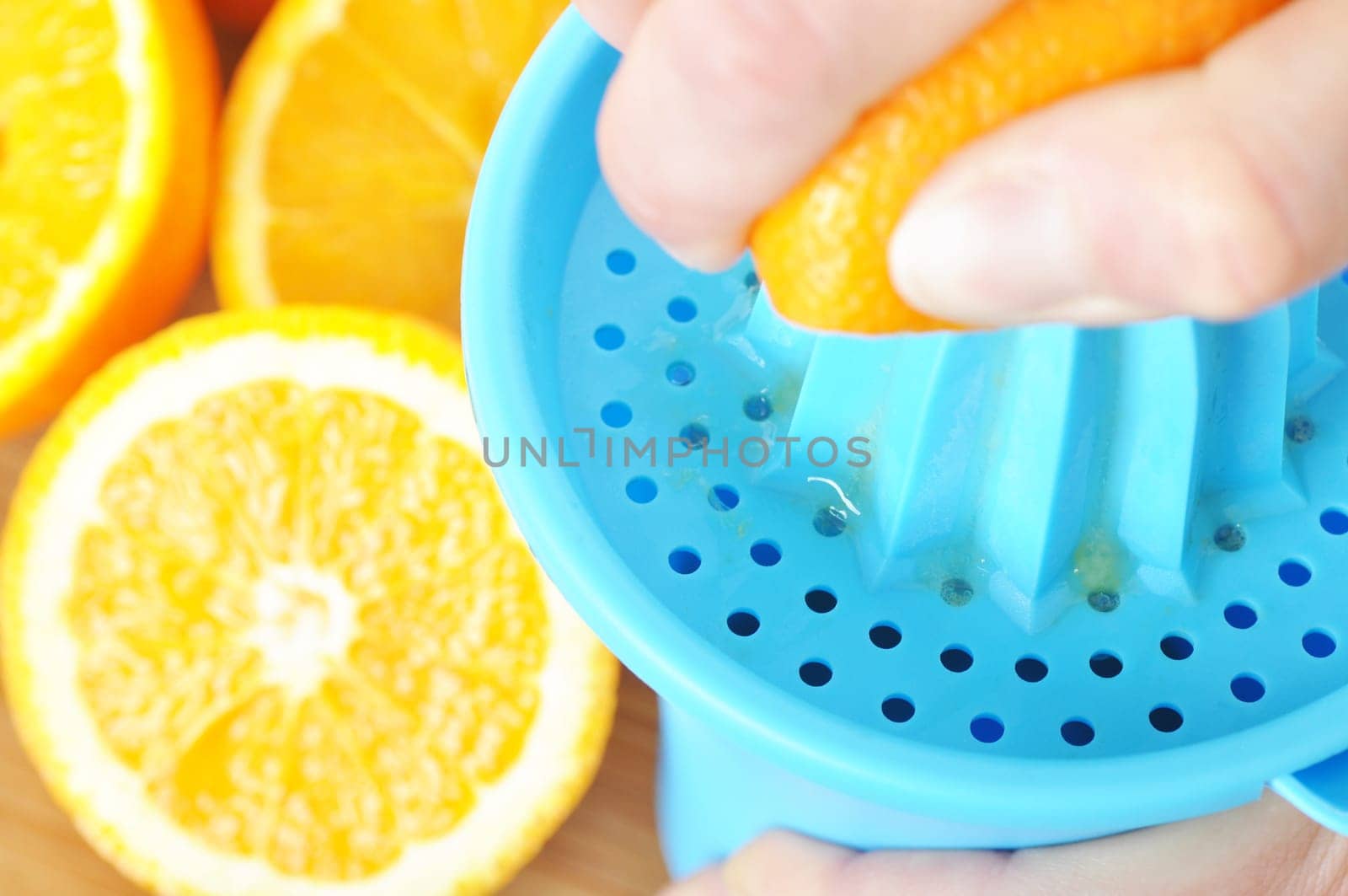 Preparing 100% orange juice using squeezer.