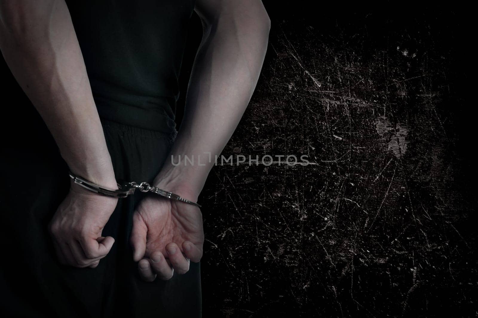 Men with handcuffs and grunge wall in background