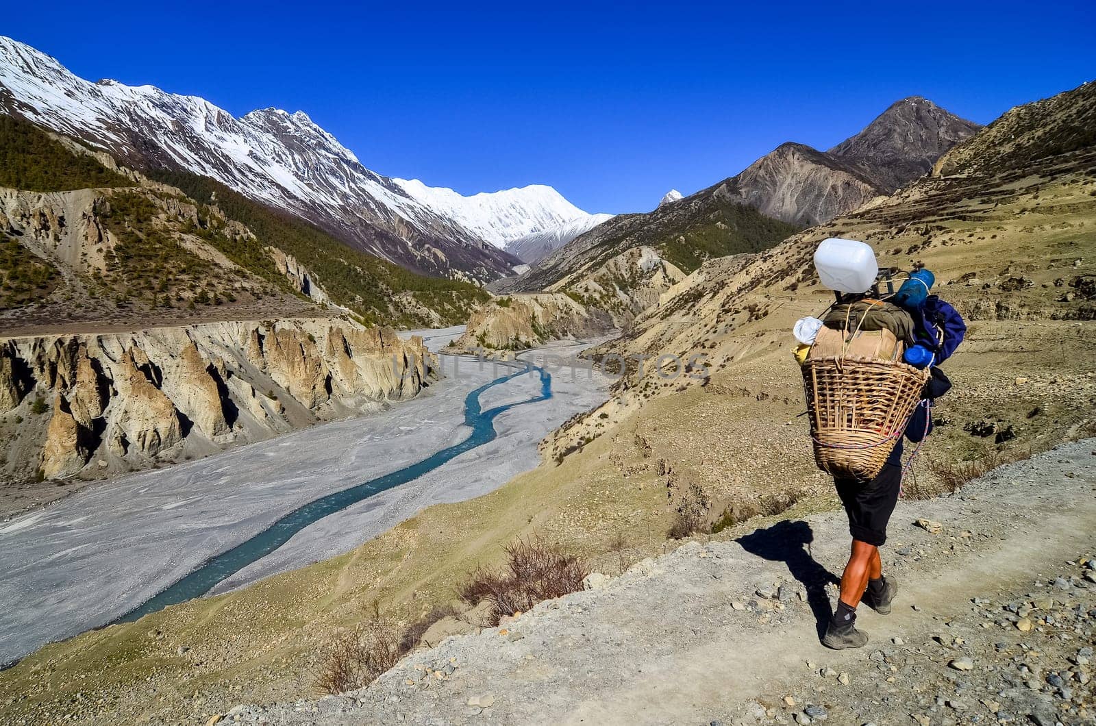 Mountain porter carrying heavy load in Himalayas, Nepal