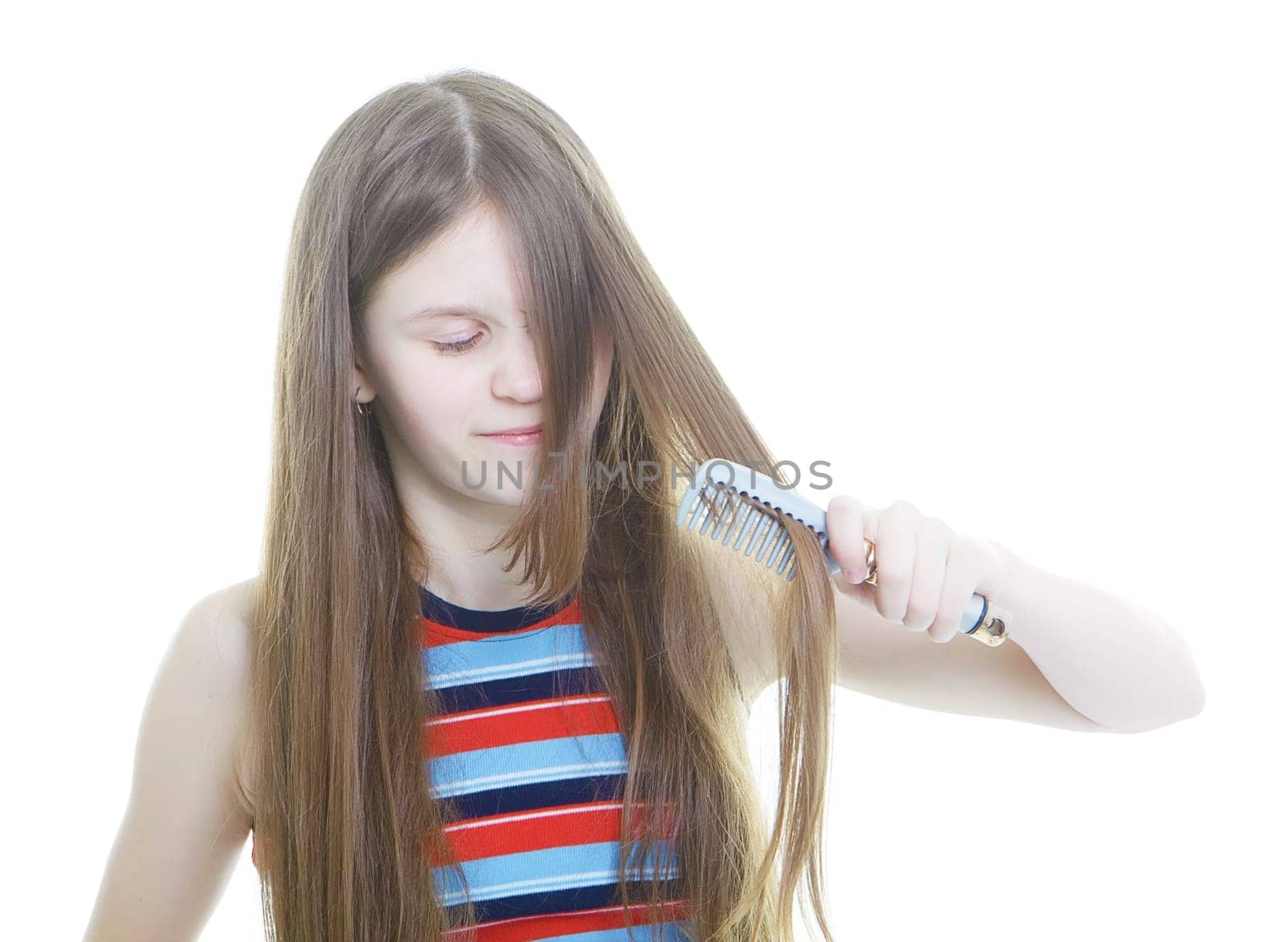 Dissatisfied with teen girl combing her long hair tangled